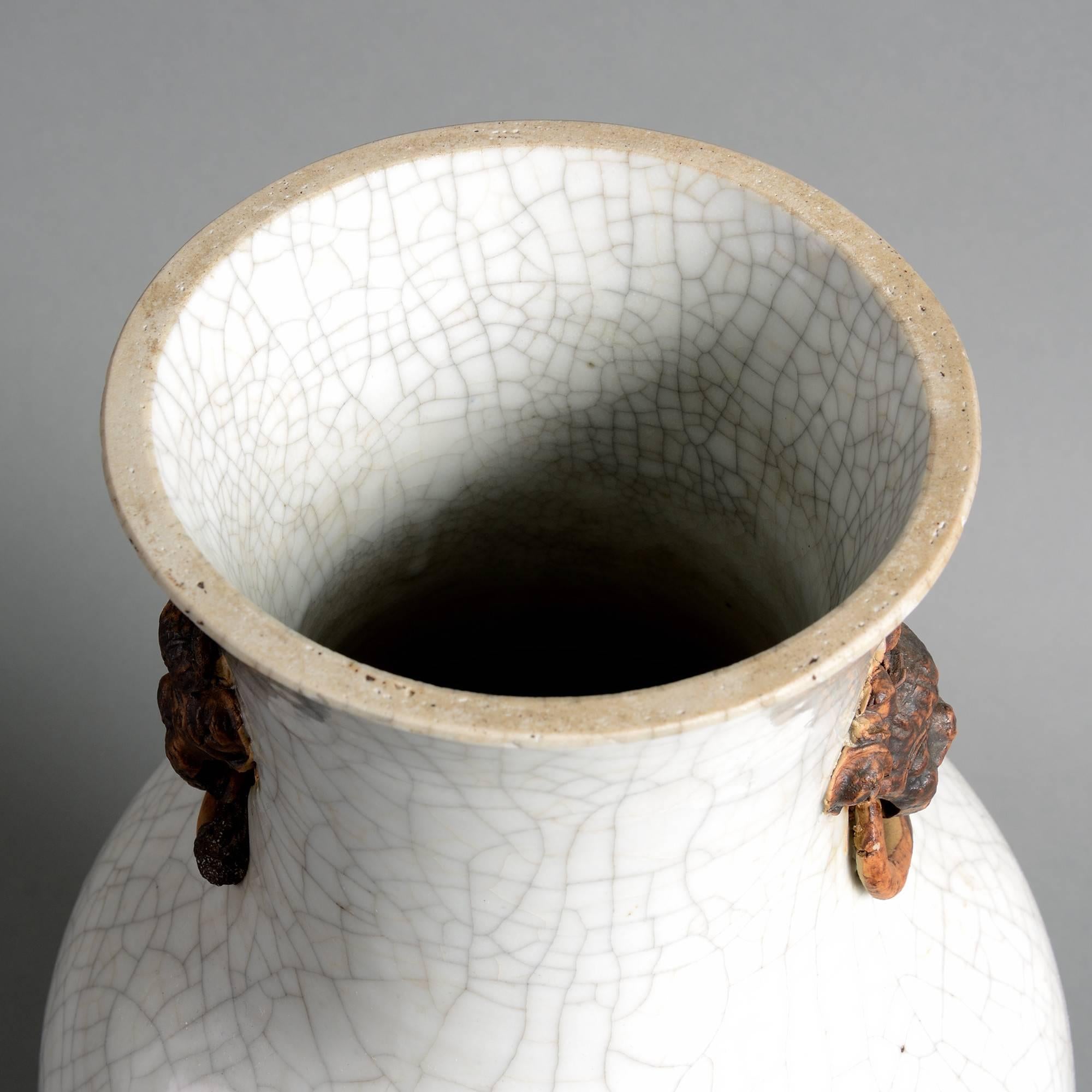 A late 19th century vase of baluster form, having applied brown glazed lion masks upon a white crackle ground. 

Qing dynasty.

Guangxu period (1975-1908).

Neck reduced in height.