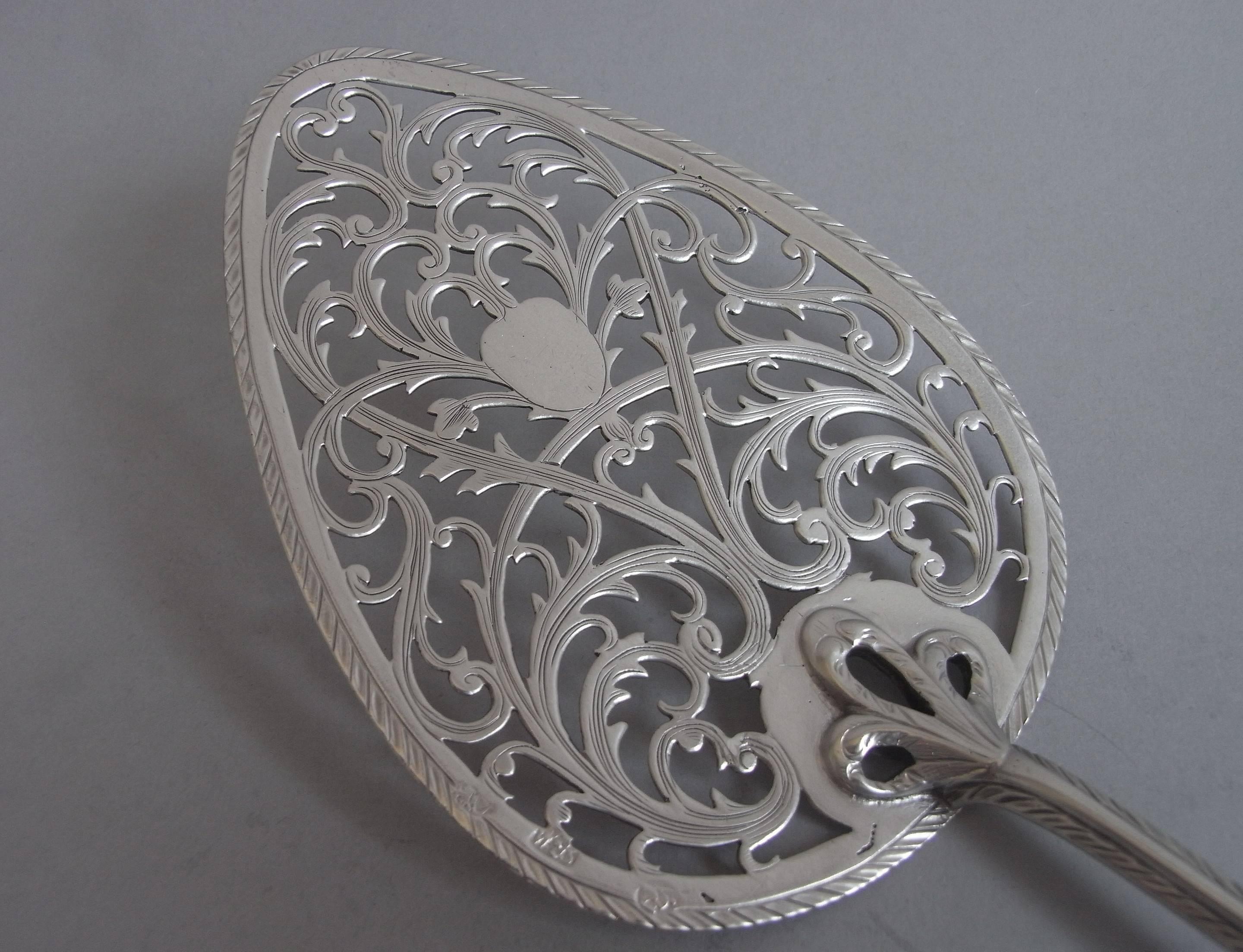 The oval shaped blade is slightly dished and completely engraved with a feather edge rim. It is beautifully pierced and engraved with foliate scrolls and flower heads, around a vacant cartouche. The cast tri-furcated moulding is joined to a feather