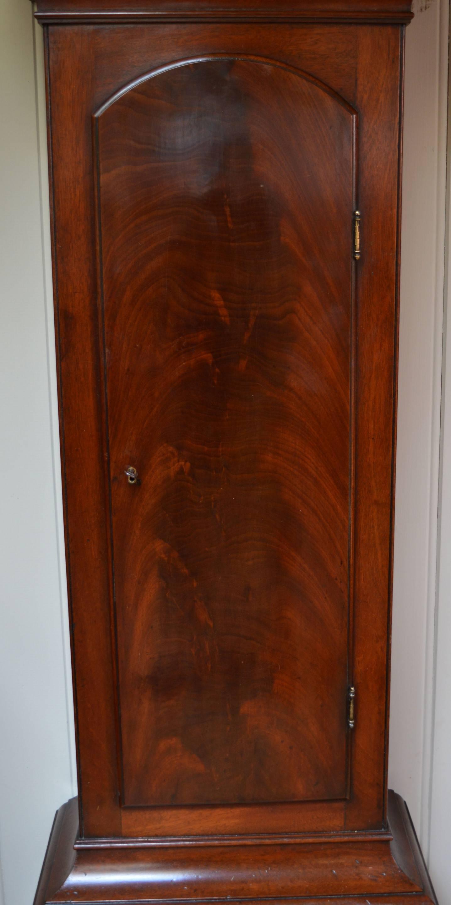 A well proportioned mahogany longcase clock dating to circa 1760. It has an arch top case with reeded side columns with brass capitals and glazed side windows. The trunk has a long figured mahogany door. The brass dial has a silvered chapter ring,