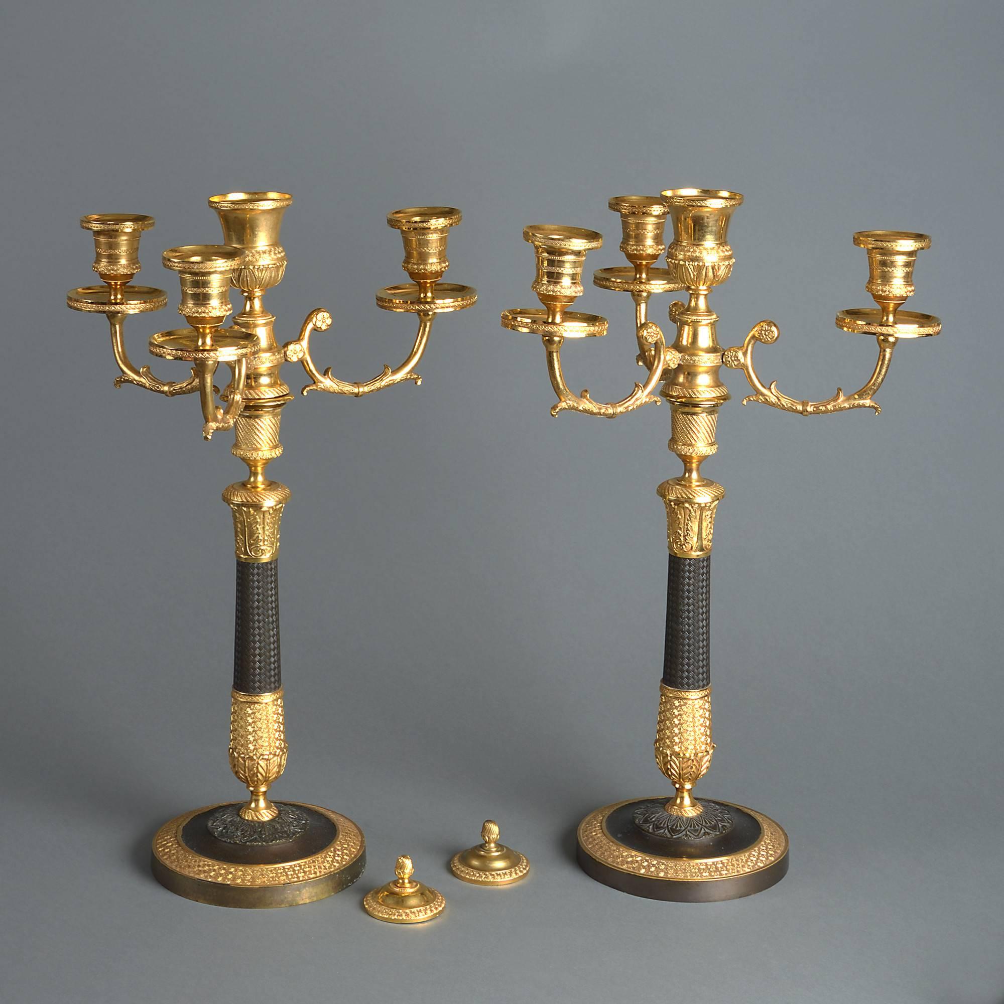 A fine pair of three branch ormolu and bronze table candelabra, finely cast and chased, each having an additional central socle with removable covers.