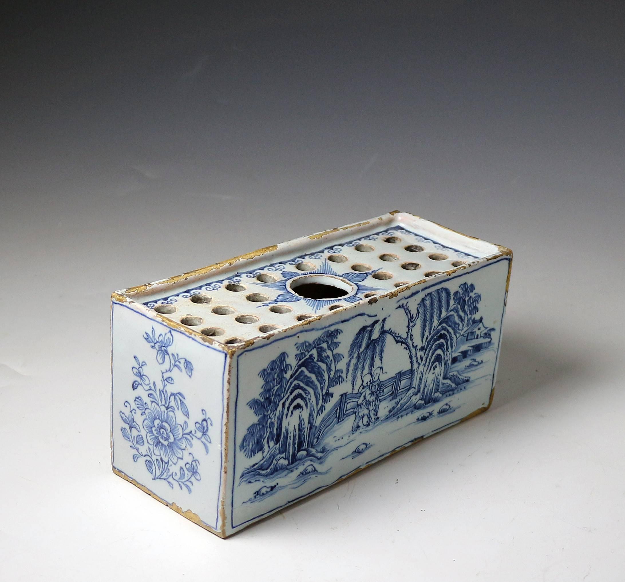 A good size English delftware pottery flower brick decorated in the Chinoiserie style in blue and white.