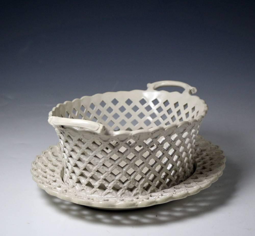A fine English salt glaze stoneware pottery basket and stand with elaborated reticulated and relief decoration. Made in Staffordshire in the mid-18th century.