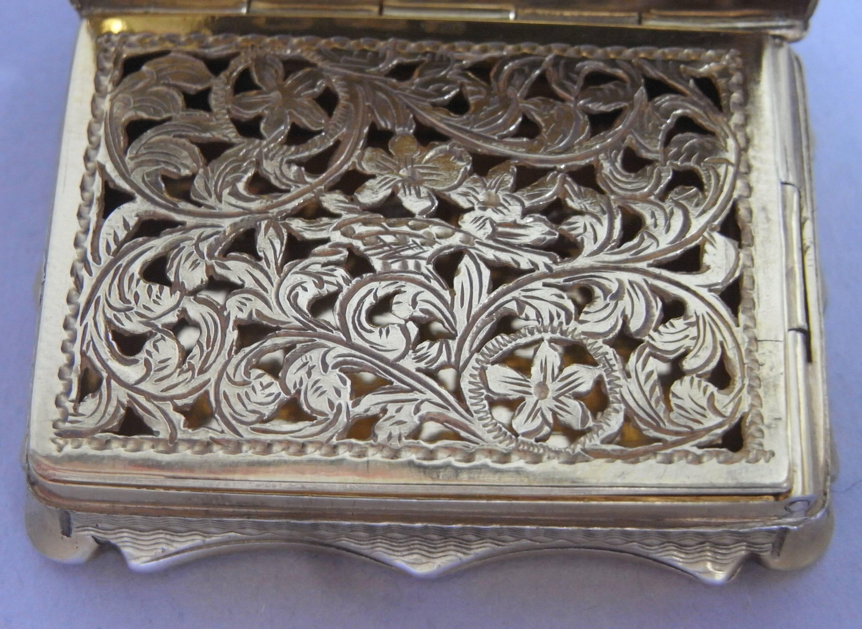 This very rare silver gilt Vinaigrette is broad rectangular in form with serpentine shaped sides engraved with a scroll work frame. The cover depicts a detailed view of Salisbury Cathedral, a very rare view to find on a Vinaigrette. The sides and
