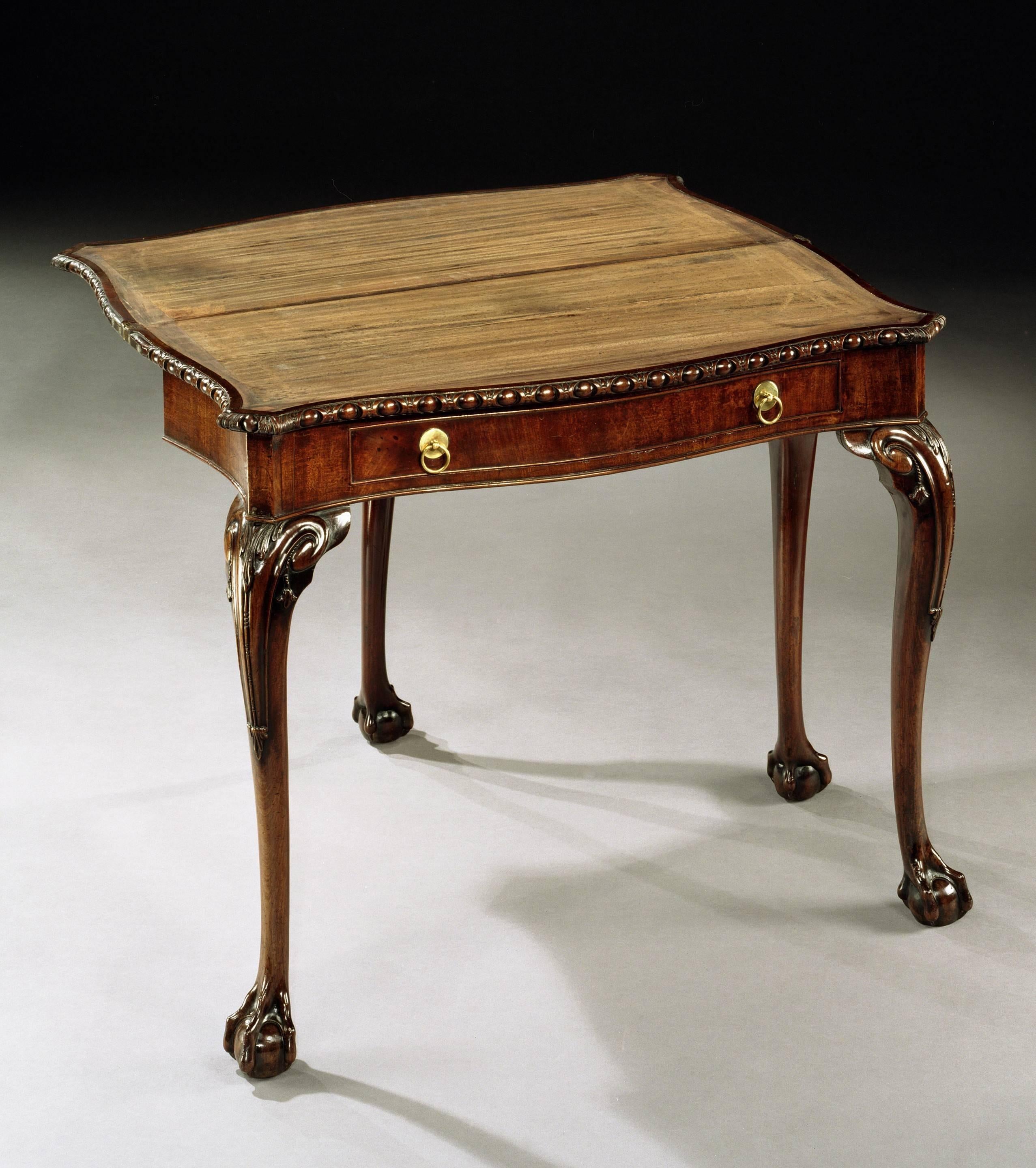 A fine mid-18th century Chippendale period carved mahogany serpentine card table, the shaped hinged top with an egg and dart edge opening to reveal a baize-lined interior with a gate-leg action above a single frieze drawer with brass ring handles,