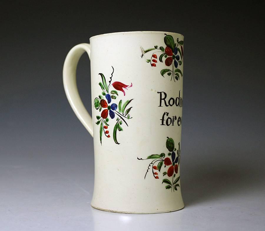 English creamware pottery tankard with flowers and foliage enameled decoration and inscribed 