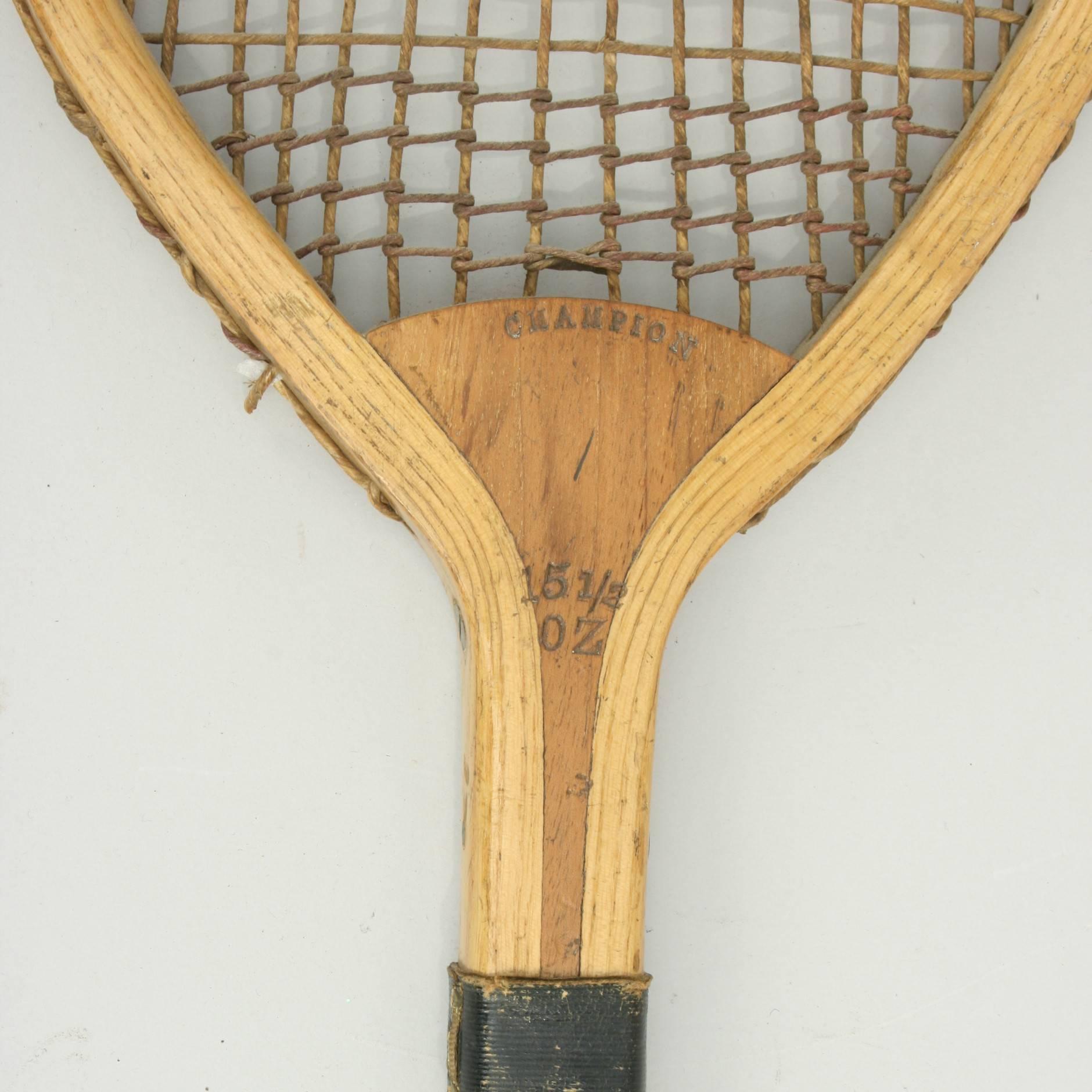 Antique lawn tennis racket. 
A wonderful 19th century ash framed lawn tennis racket, 'Champion' with original thick gut stringing (some damage) and trebling on top and bottom. The cedar wood handle, with thin grooves and a black leather collar with