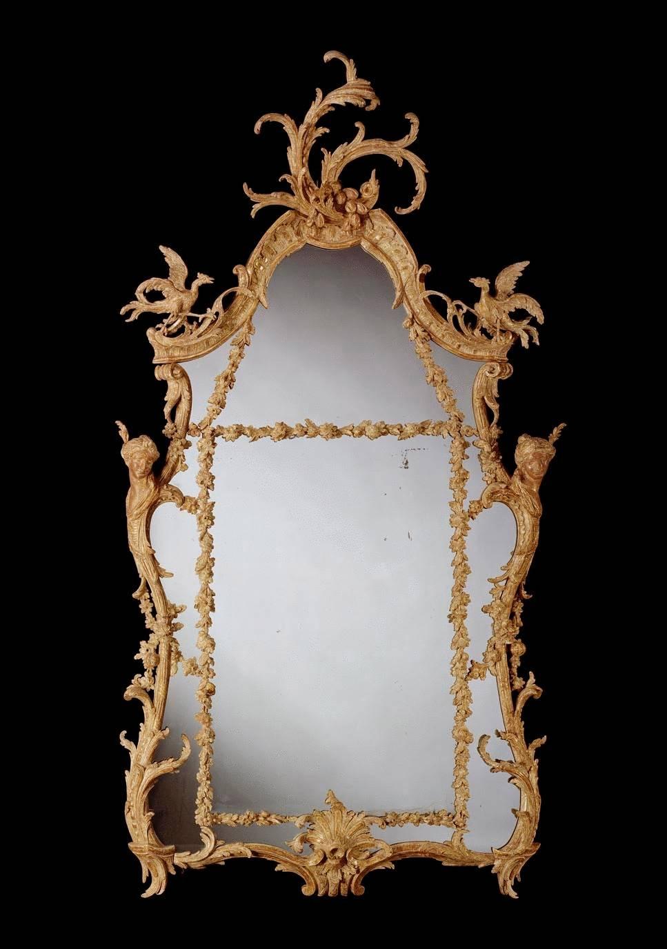 An outstanding pair of mid-18th century Chippendale period carved giltwood border glass mirrors, retaining mainly original gilding and having 18th century replaced plates divided by floral and foliate carved slips within a lobed and arched frame,