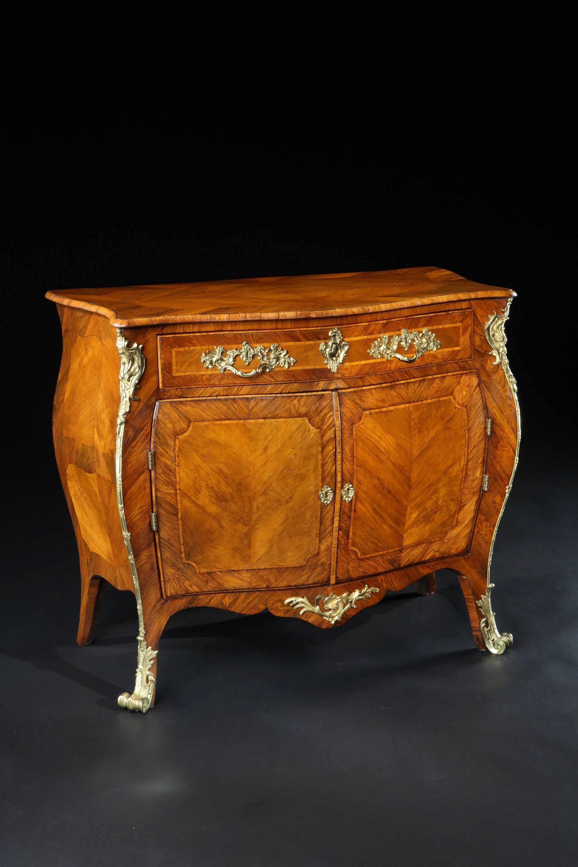 An important and rare pair of mid-18th century Chippendale period rosewood and padouk ormolu mounted bombe commodes attributed to Pierre Langlois. Each having a serpentine shaped quarter veneered top, diagonally crossbanded in rosewood and outlined