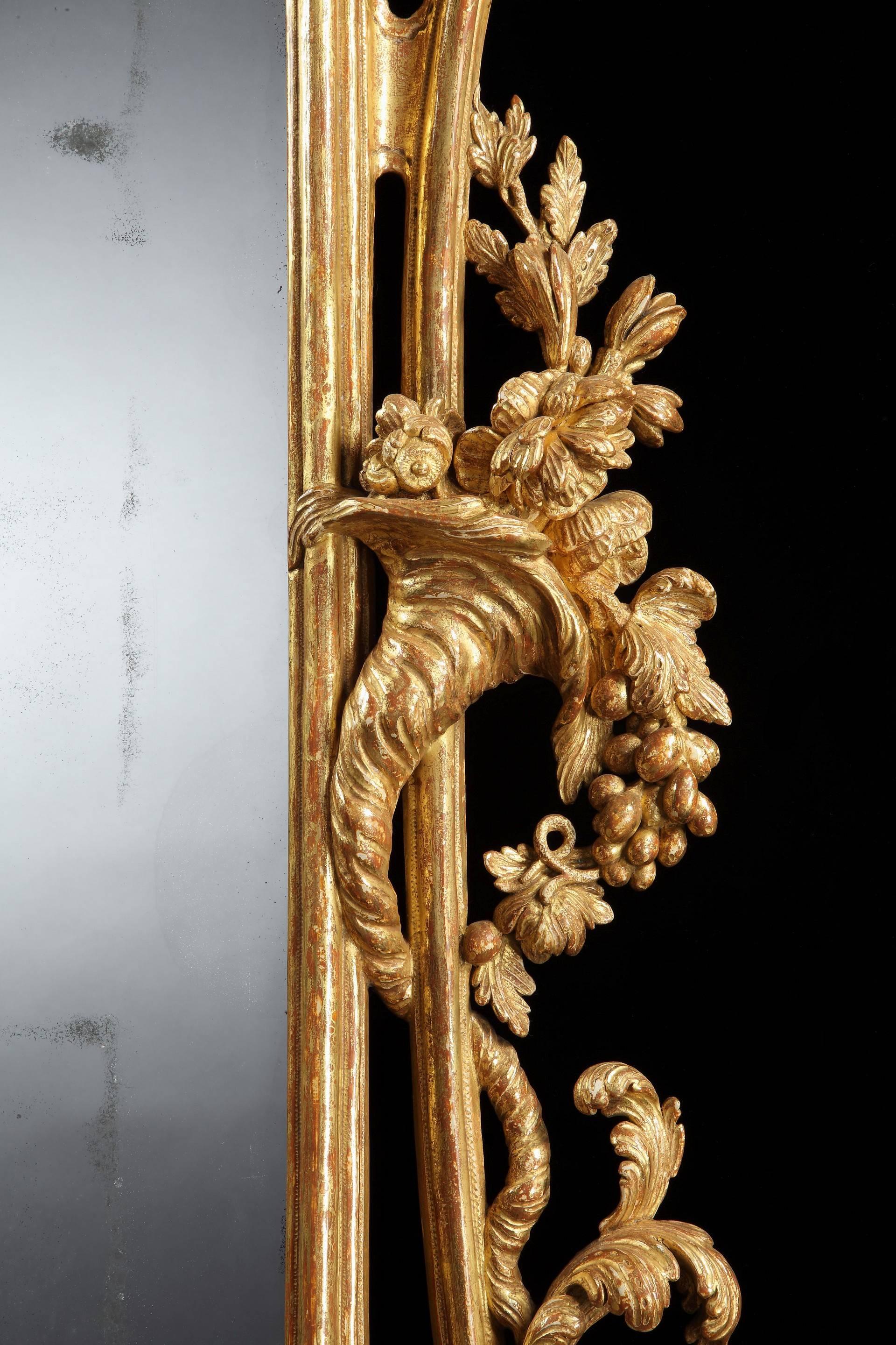 An important and large pair of mid-18th century Chippendale period carved giltwood pier mirrors, each having divided upright rectangular 18th century replaced mirror plates with foliate carved division fillet within a moulded frame with stylised