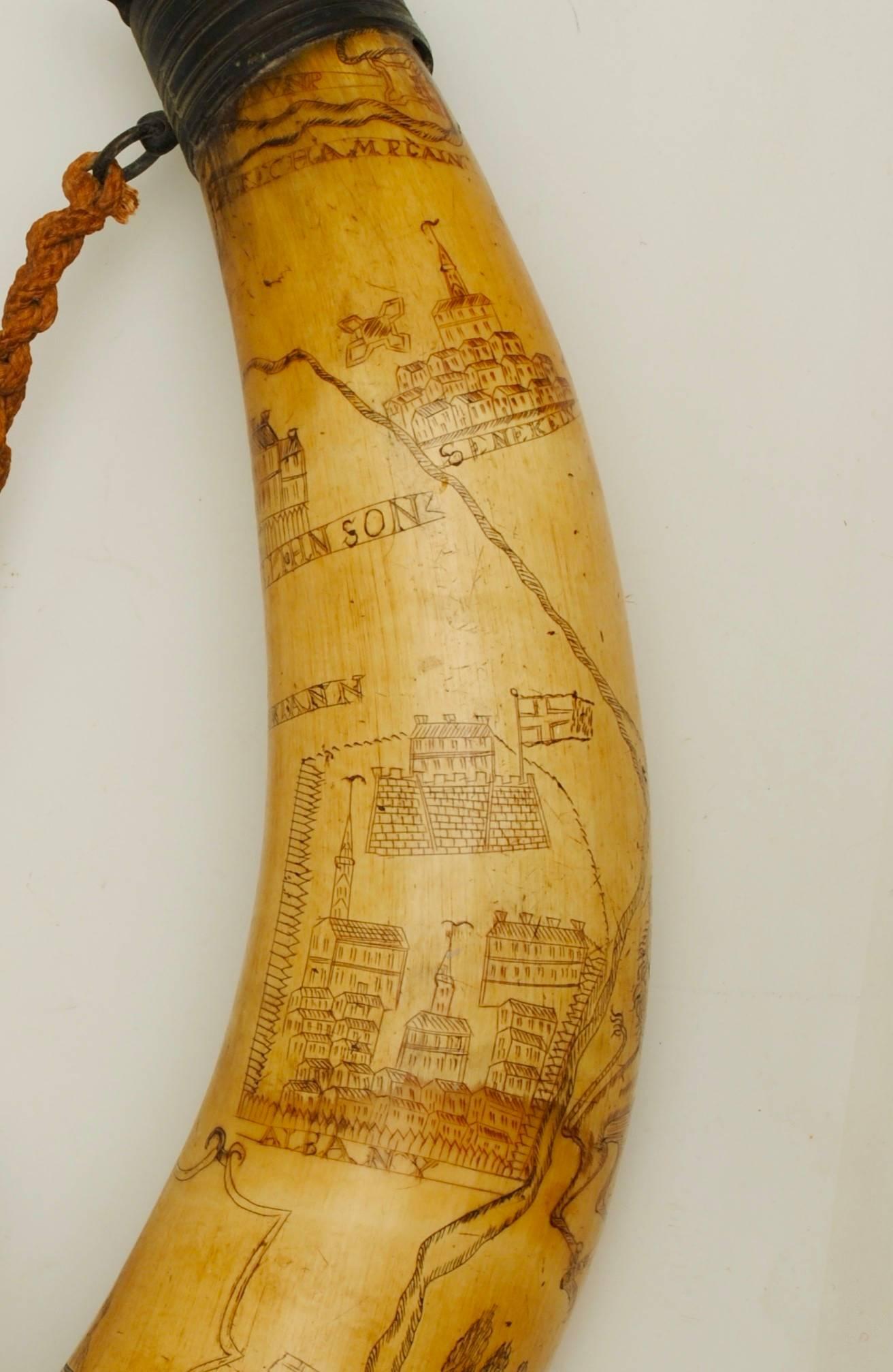 A well engraved American horn powder flask engraved with a royal coat of arms and a map of the Hudson River and views of New York. The fittings an early 19th century addition to bring it up to date so it could be used to dispense powder, these do