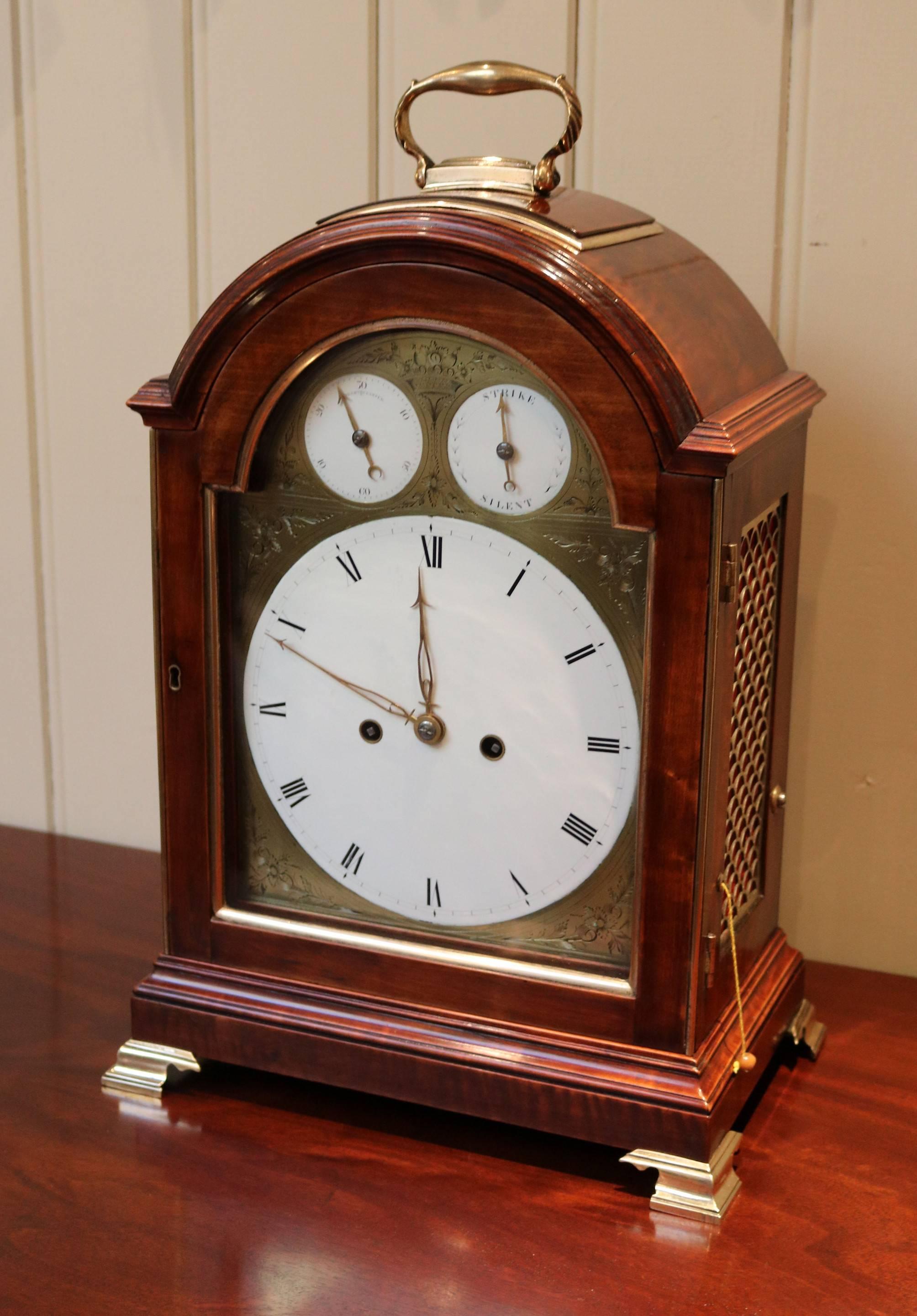 A well-proportioned pad top bracket clock dating to the late 18th century. The pear wood break arch case has a pad top with a brass carrying handle, brass side frets and ogee bracket feet. The well engraved brass dial has a convex enamel centre dial