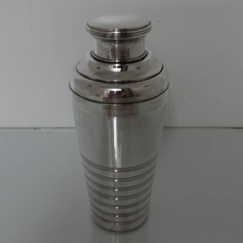 A very good quality Art Deco three sectioned designed cocktail shaker. The cocktail shaker has seven decorative bands of engraving for lowlights and is marked AMA 20.