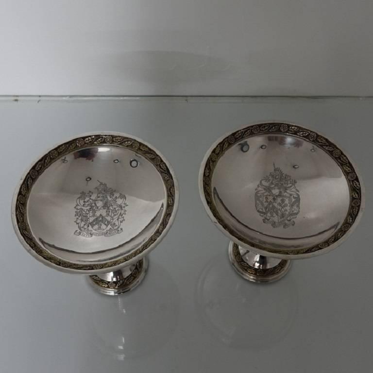 A highly collectable pair of commemorative silver comports/tazzas partial gilt throughout. The comports have an elegant coat of arms in the center of the bowl. The foot of the comports are highly decorative with cast lions holding shields as the