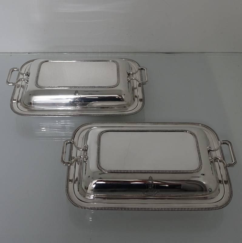 A very stylish pair of plain-formed side handled gadroon entrée dishes with single crests. The lids of the entrée dishes are detachable with gadroon on the underside so that they can be used either as pair or four separate serving dishes when one