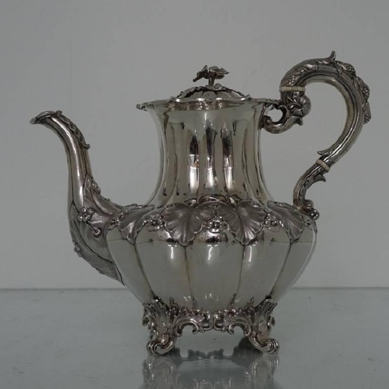 An exceptionally beautiful five piece tea and coffee service with rare matching slop bowl. The service is melon shaped in design with acanthus leaf hand chasing for decoration. The tea and coffee pot have floral decorated scroll handles and all