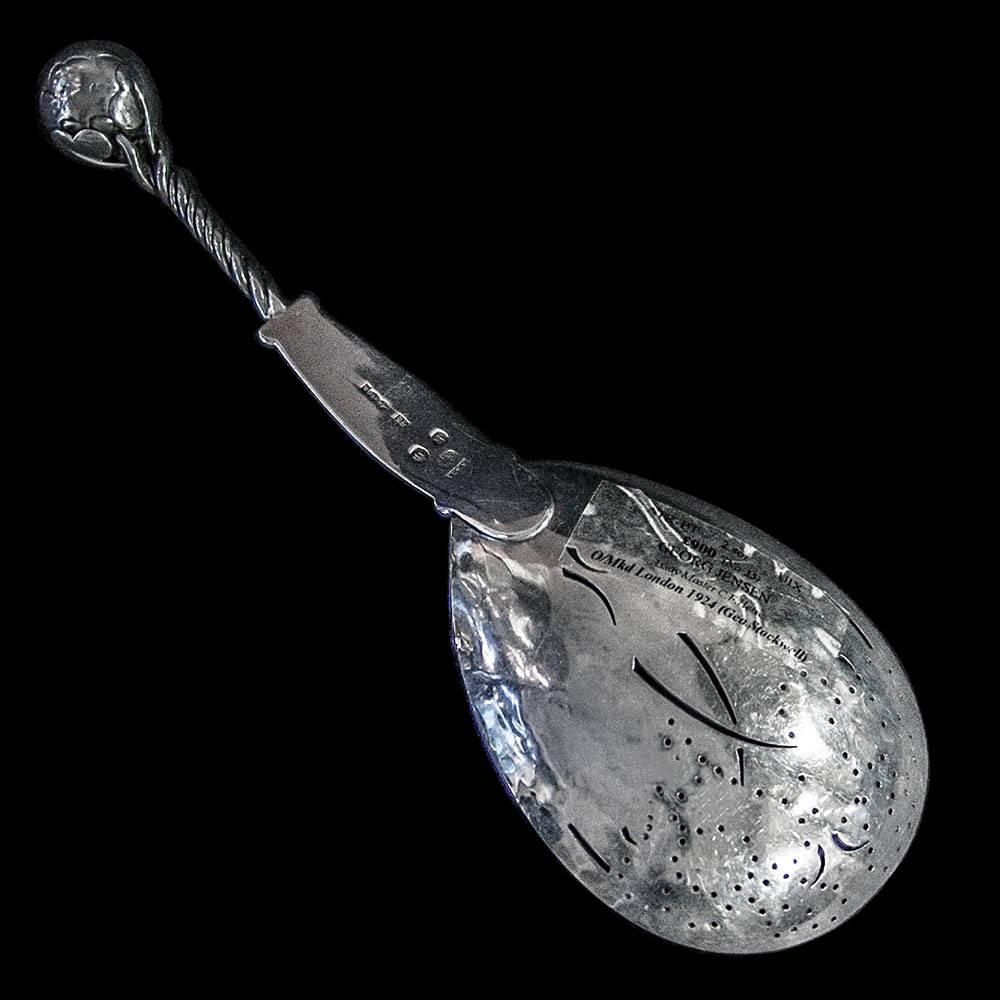 A Georg Jensen silver serving spoon, design no.35. The pierced bowl embellished with engraved leaf design. The twisted stem handle surmounted by a leaf and ball finial.