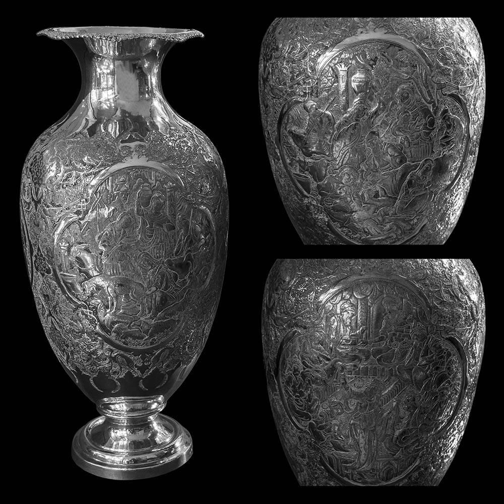 A large pair of Persian silver footed vases of ovoid shape with flared neck over the shoulders and flared rim. Chased and engraved with floral and bird design. Each having panels depicting figural and animal scenes. Stamped with Persian silver marks