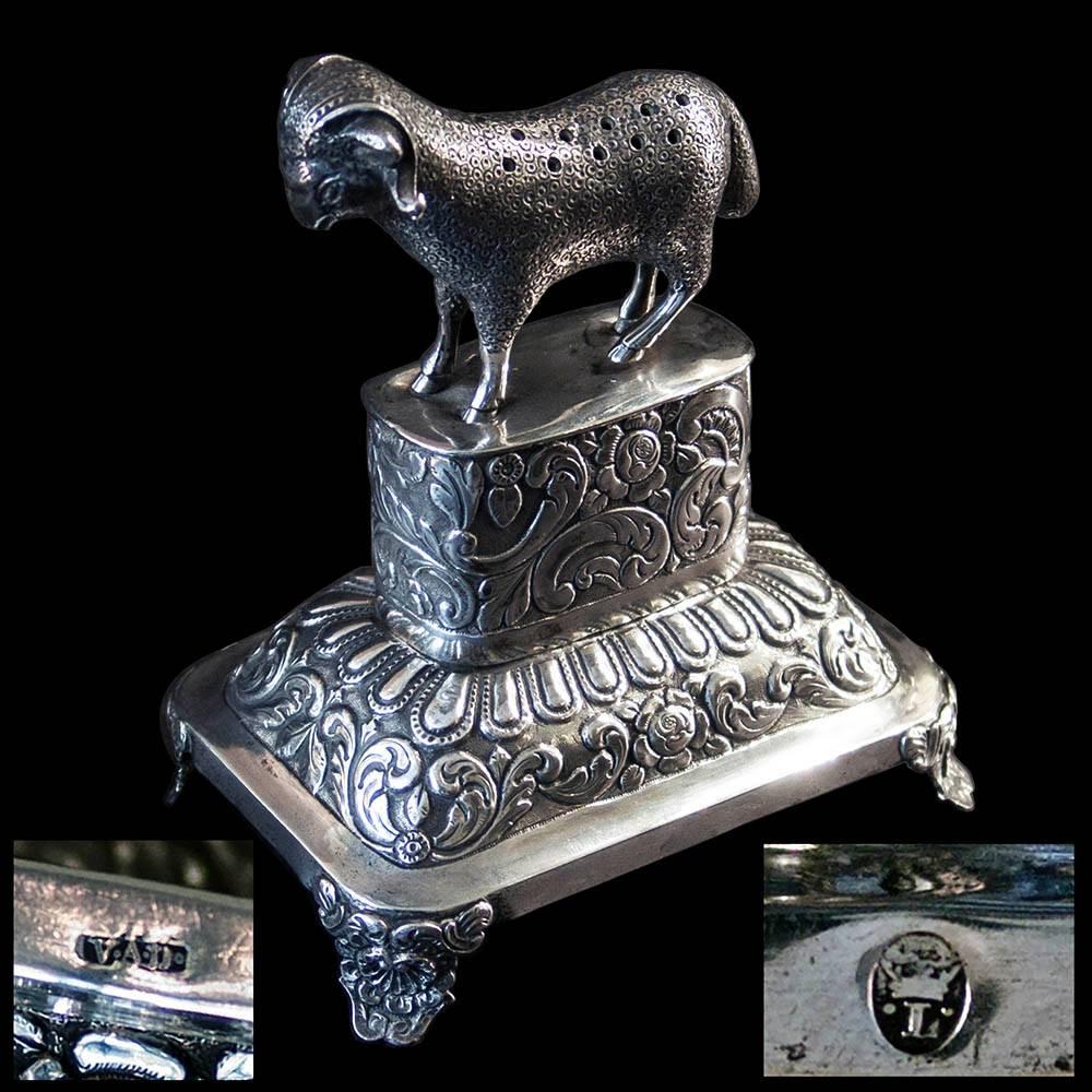 A Portuguese silver toothpick holder. Mark of V.A.D. (unidentified) Lisbon. Modelled as a 'ram' on foliate chased plinth, raised on four shell decorated bracket feet.