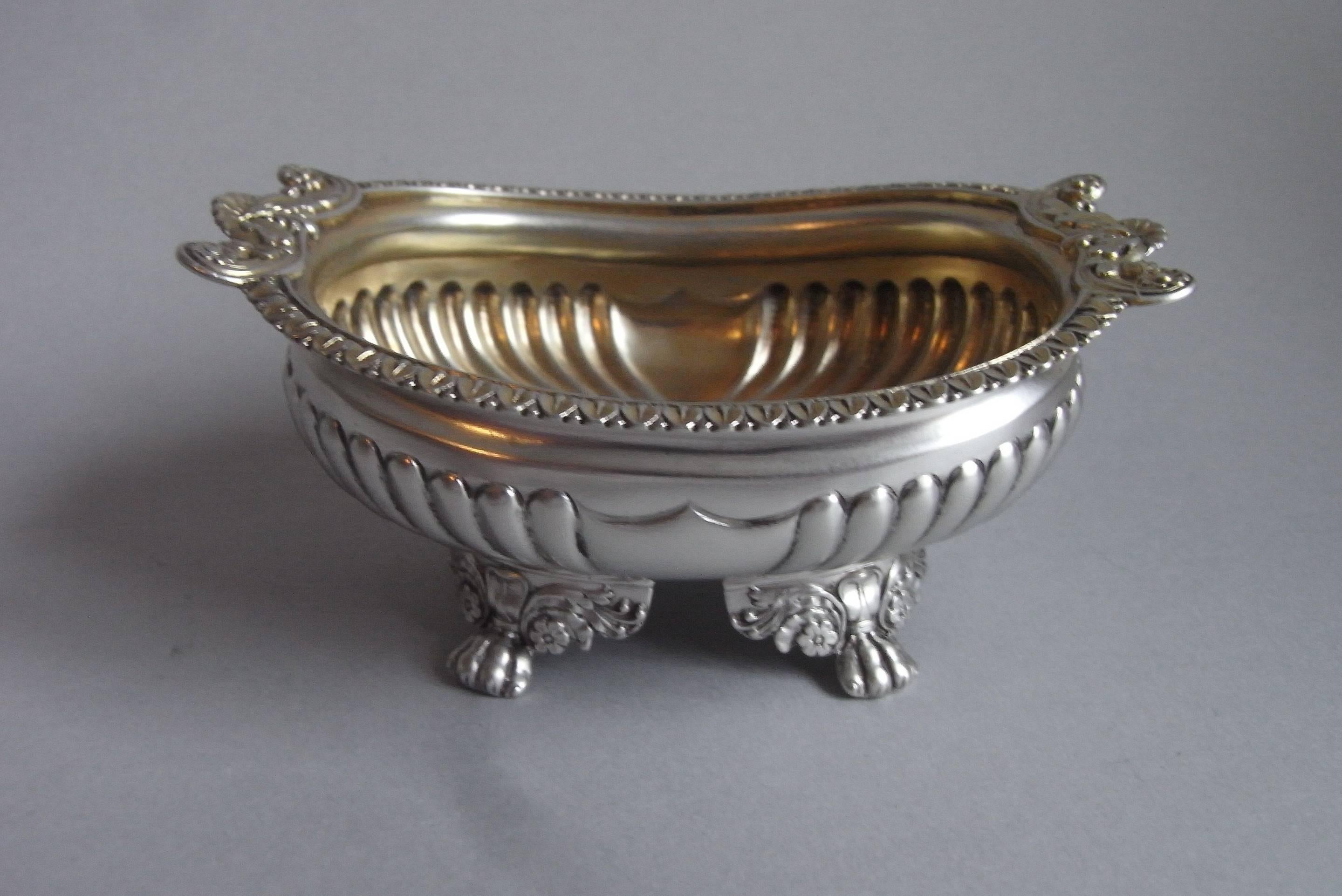 The salt cellars are rectangular in form and Stand on four floral and foliate winged paw feet. The baluster main bodies are decorated with lobing and display a vacant shield shaped cartouche on each side. The everted rim is decorated with foliate
