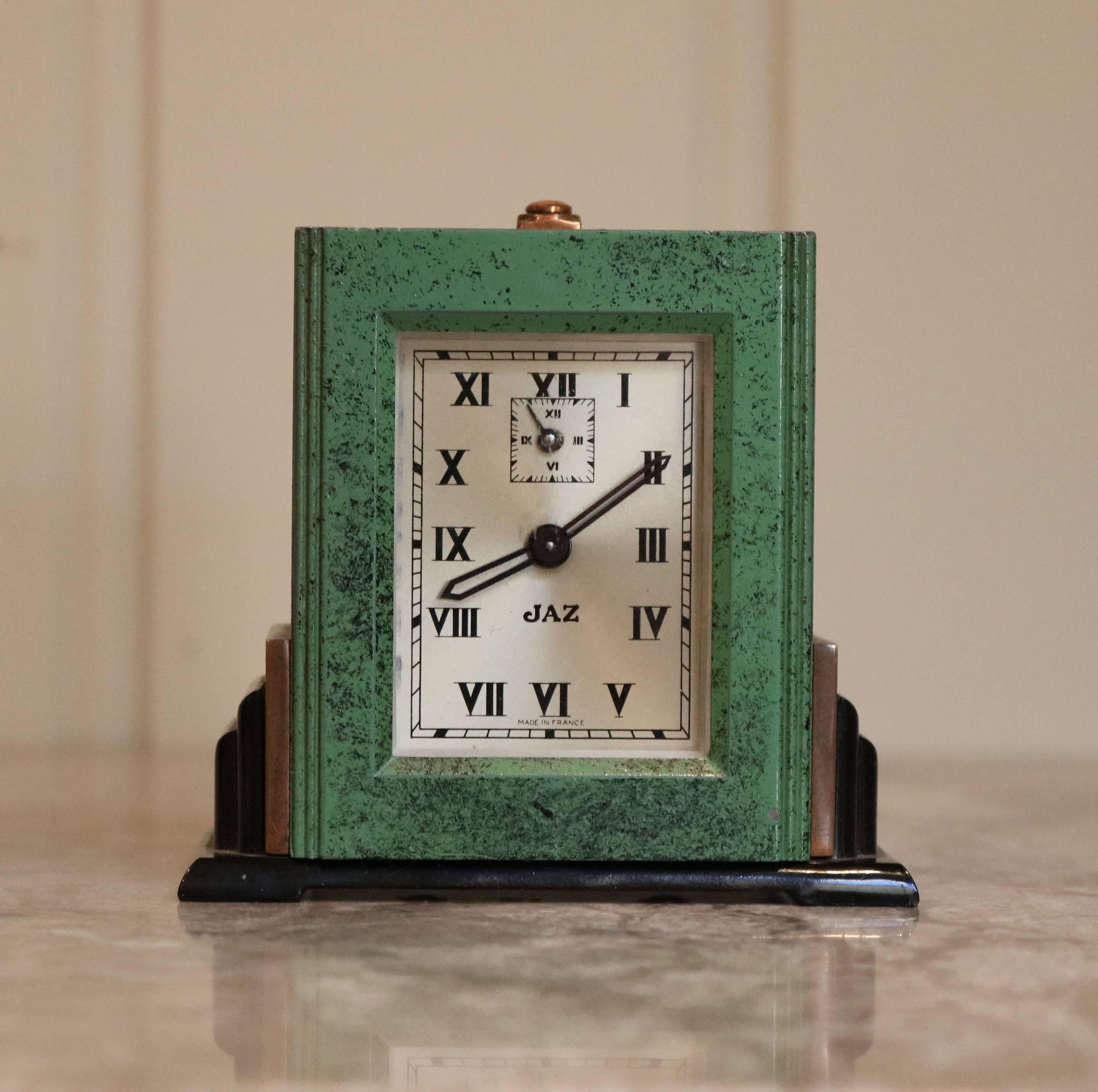 A delightful small proportioned French travelling alarm clock in green patinated case and matching fitted travelling case. The clock itself is brass with bakelite base and square silvered dial signed 