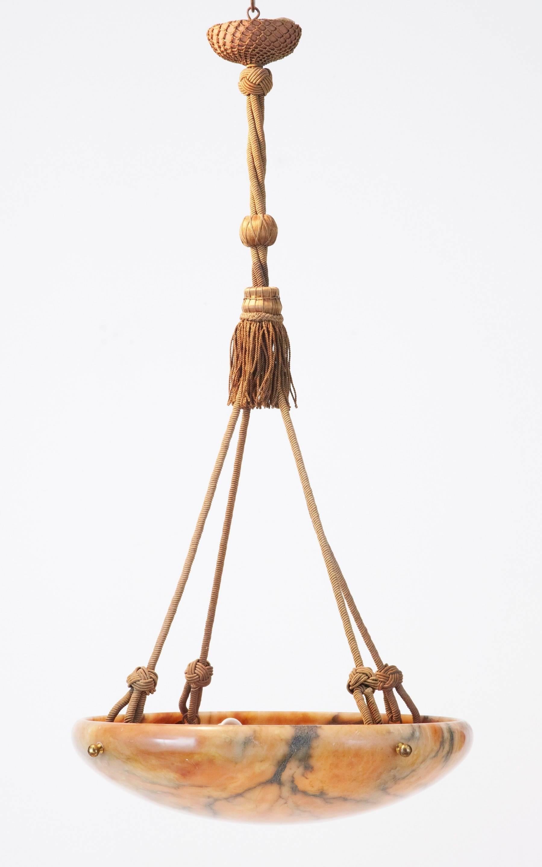 Fine alabaster hanging ceiling light, circa 1920.
Peach colored stone with grey veining.
Four light fittings, which form the anchor for the four rope supports, leading up to tassels and the strung ceiling rose.
Untested, we recommend that this