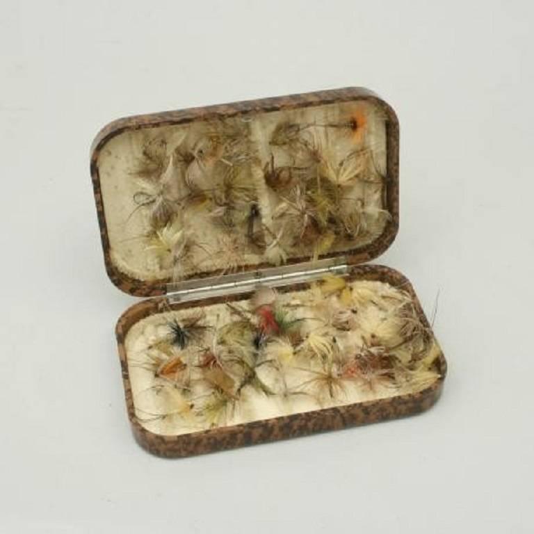 A good Neroda Wet or Dry fly box made from bakelite with a brown tortoiseshell finish manufactured by Hardy's of Alnwick. The flies are hooked over the chenille covered bars and cannot drop out or change position. Hardy's say about these boxes:- 'A
