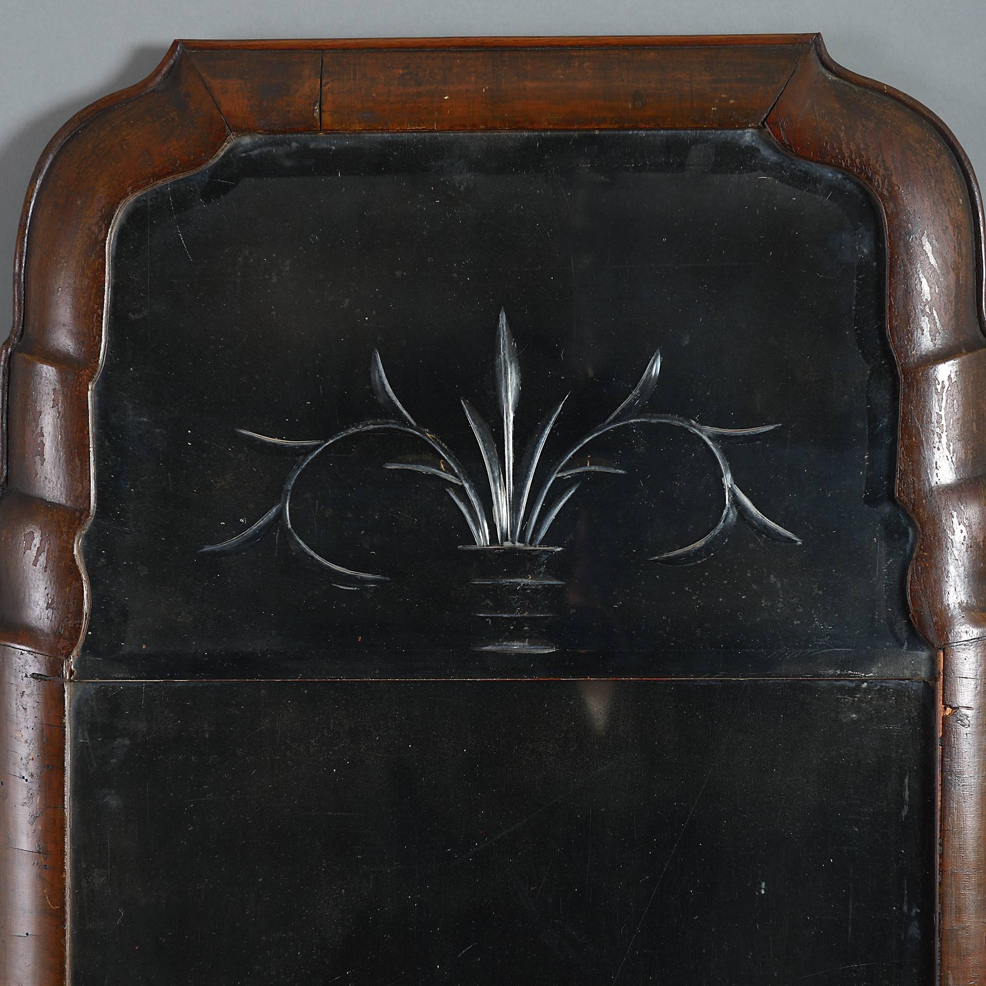 An early 18th century Queen Anne period walnut period mirror, having a shaped cushion moulded frame housing three bevel cut plates. 

The lower plate has most probably been taken from another mirror of the same period.