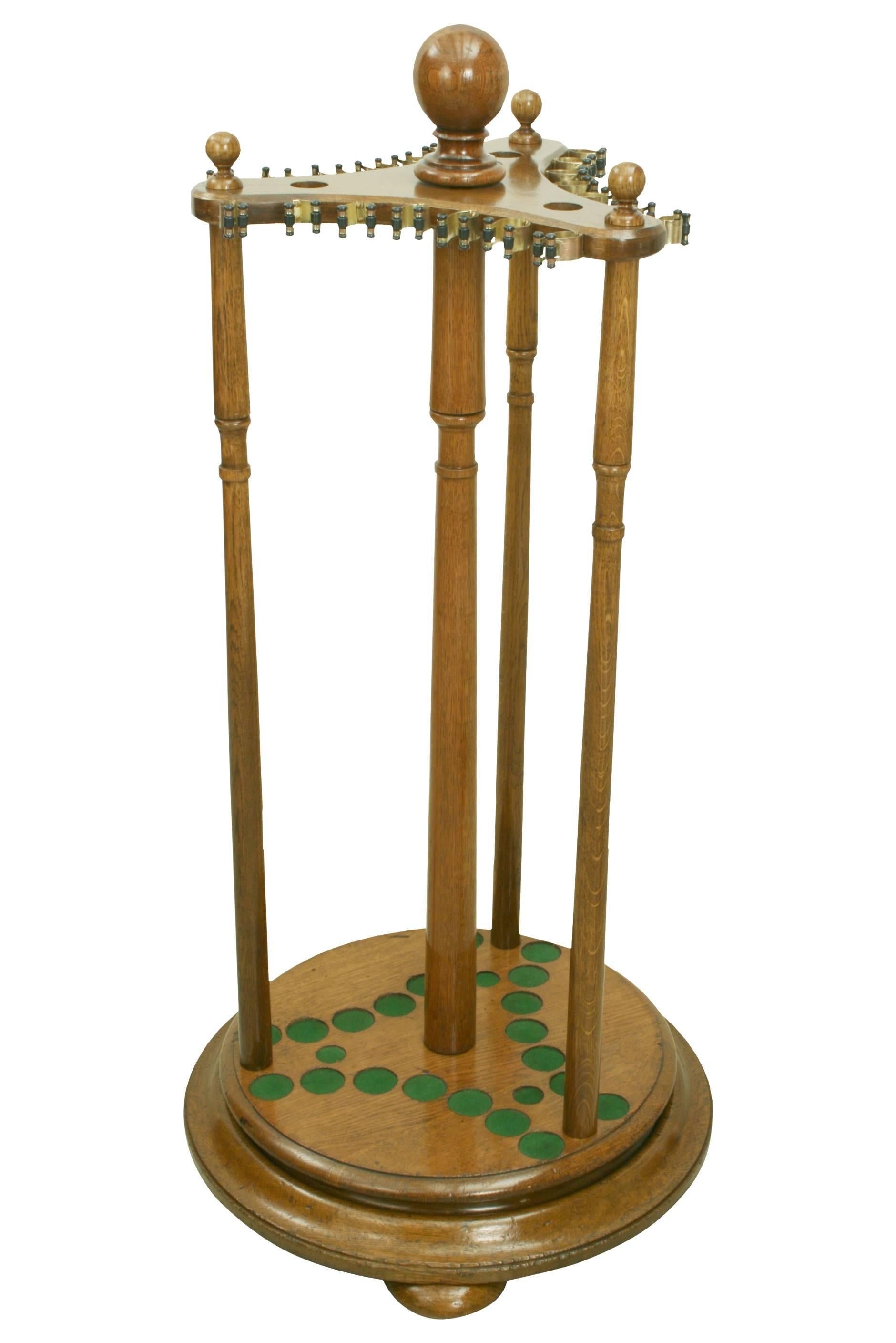 A fine quality oak billiard or snooker cue rack raised on three bun feet and revolving around a central turned pillar. The Stand is designed to hold twenty four cues and rests, twenty one around the outside held in place by brassed spring clips and