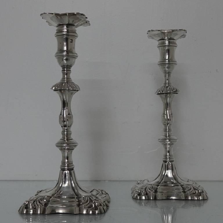 A very stylish pair of Georgian candlesticks with shaped square bases decorated with shells at the angle. The columns have additional shell decoration and are crowned with a elegant plain formed capital. The nozzles are detachable.
