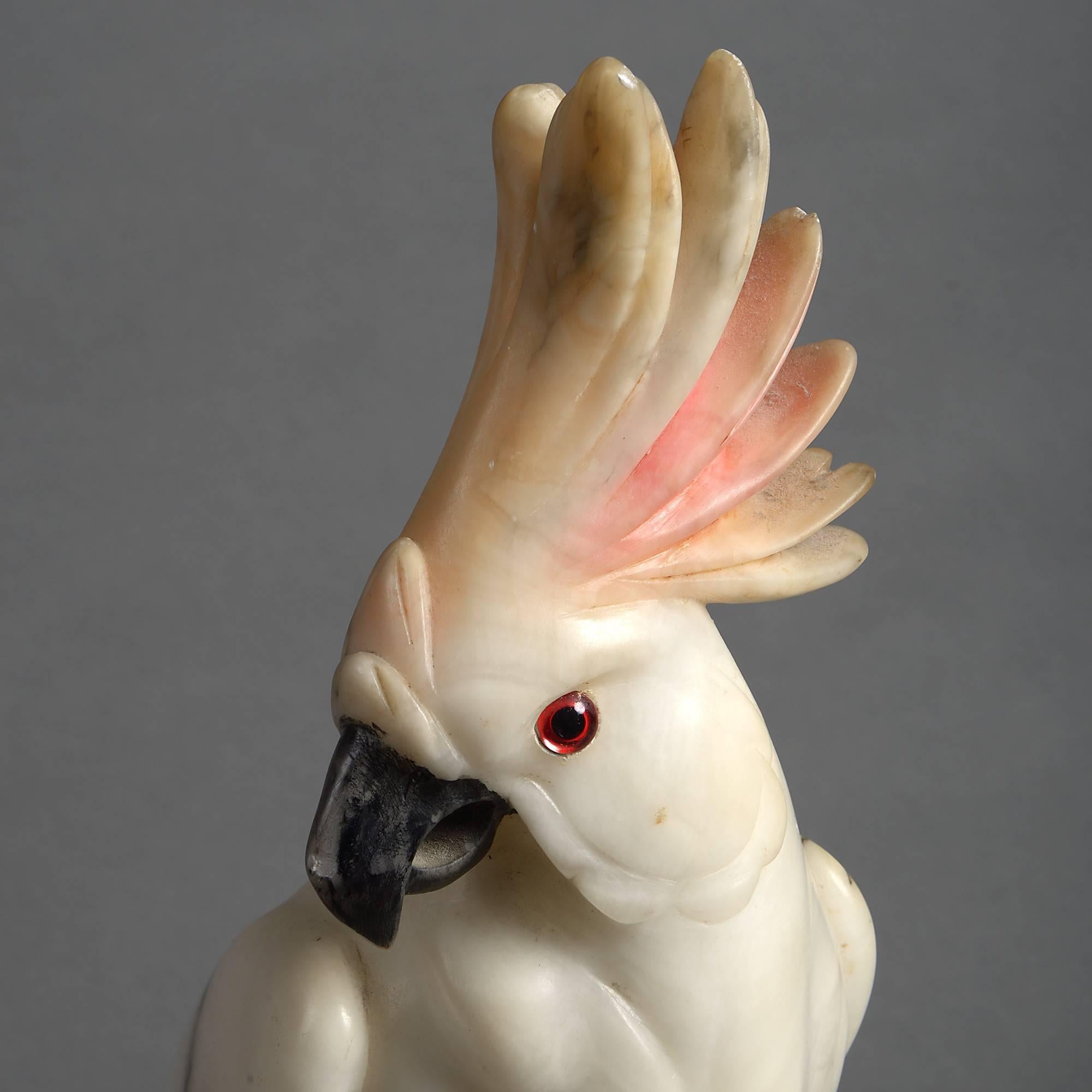 An early 20th century carved alabaster cockatoo of good scale having colored glass eyes and set upon a stylised rock.