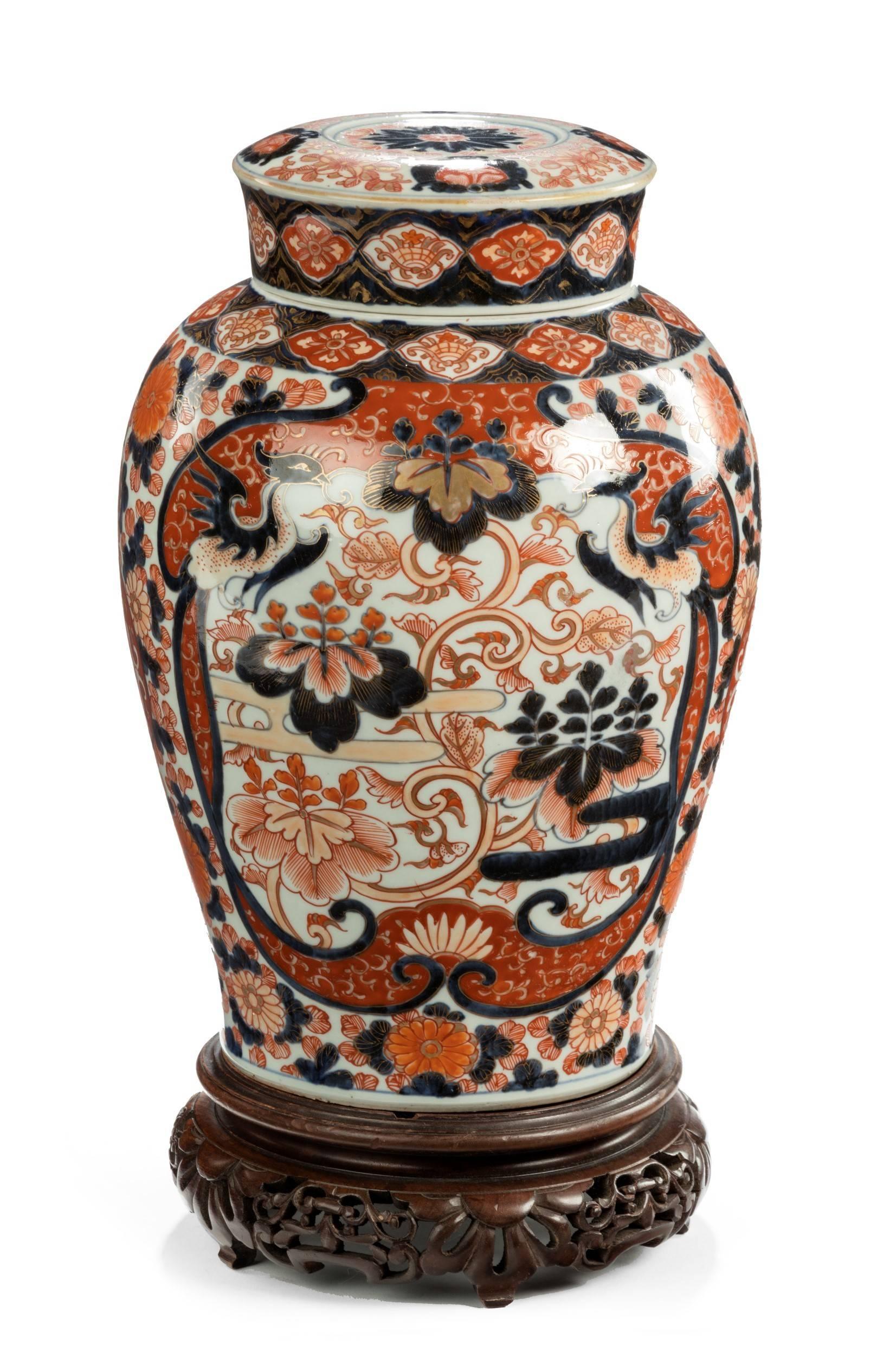 A large single Imari vase with cover. Painted in a typical palette iron-red, under glaze blue and gilt decoration with winged phoenix. A/f chip on lid. Hardwood stand not included.