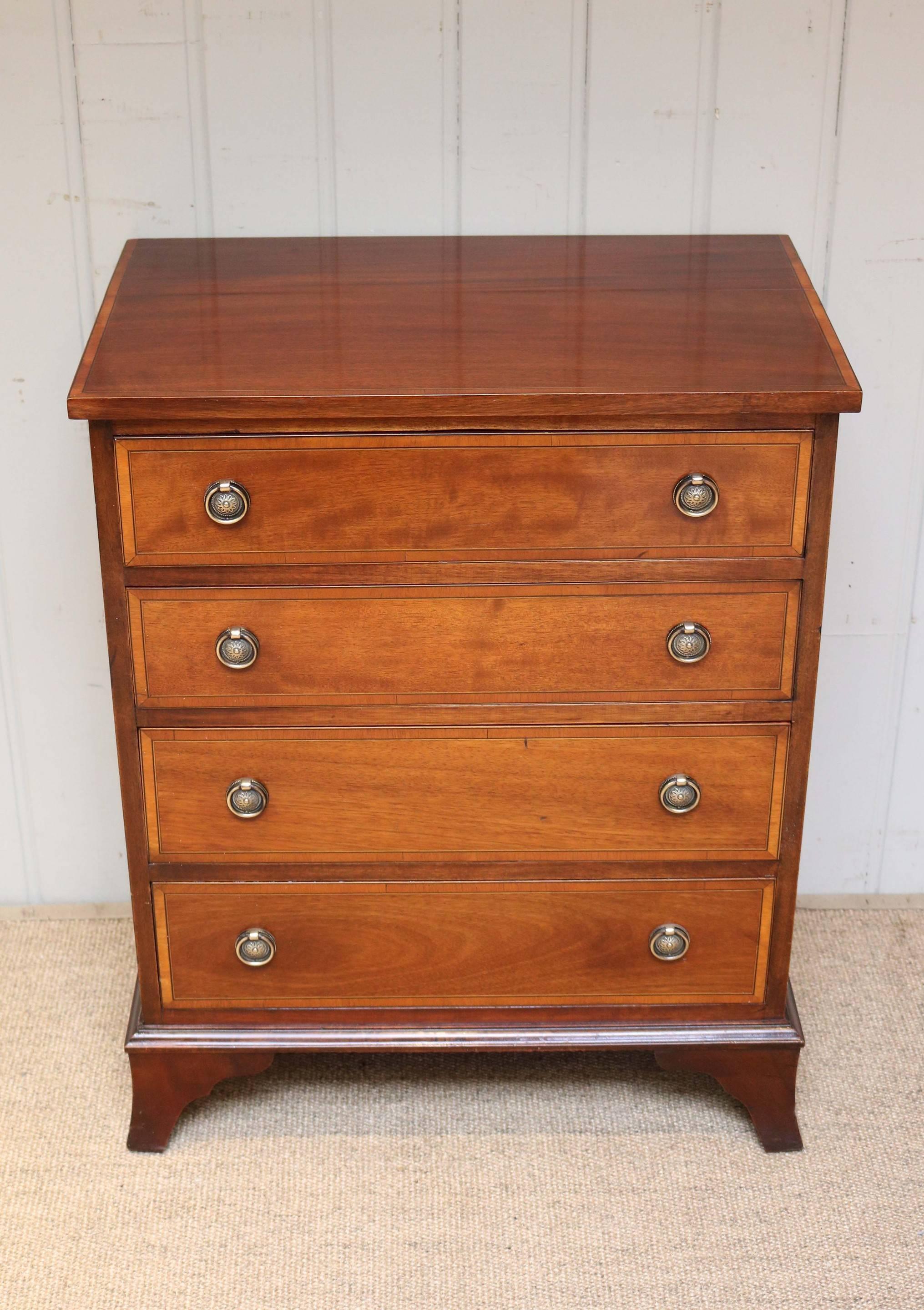 Small mahogany chest having four graduated drawers with boxwood and ebony crossbanding raised on outsplayed bracket feet.