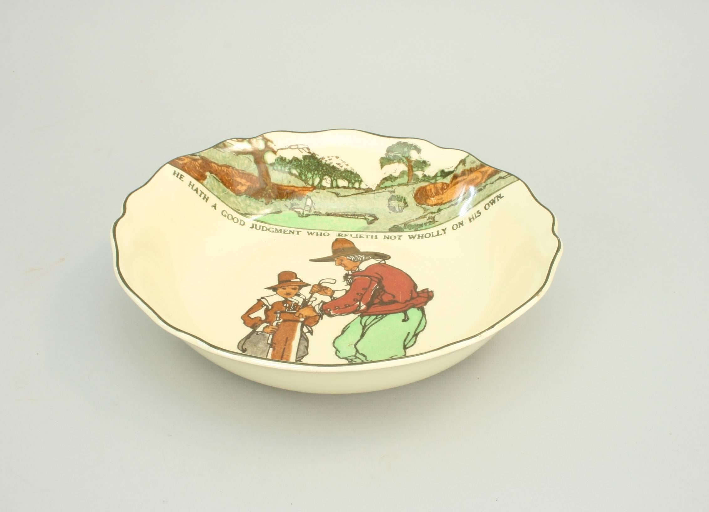 A Royal Doulton bowl with polychrome golfing scene entitled: 'He Hath A Good Judgment Who Relieth Not Wholly On His Own' by Charles Crombie.
Charles 'Chas' Crombie (1885 ? 1967) was an illustrator whose work is well-known to the collector. His