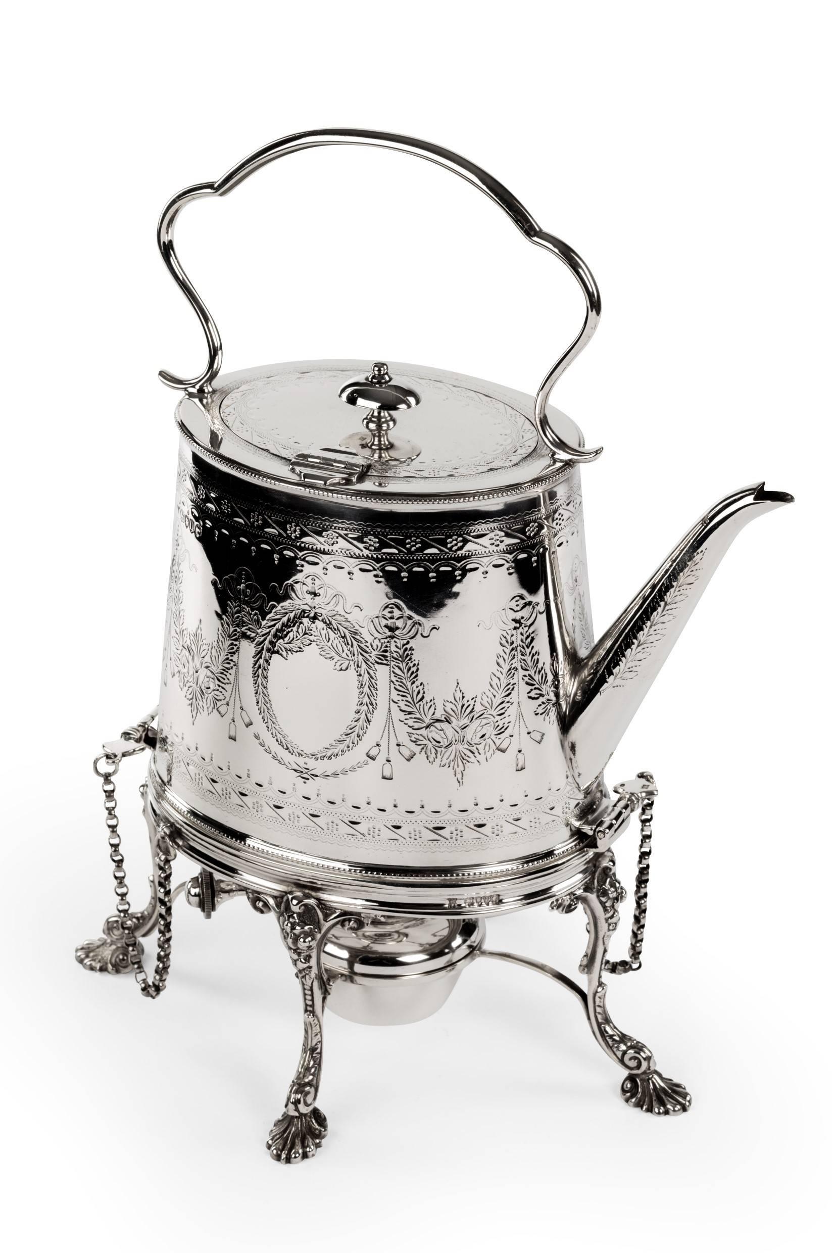 William Hutton, London, 1879. A Victorian sterling silver tea kettle on a burner stand. Oval in shape with straight sides and engraved body.