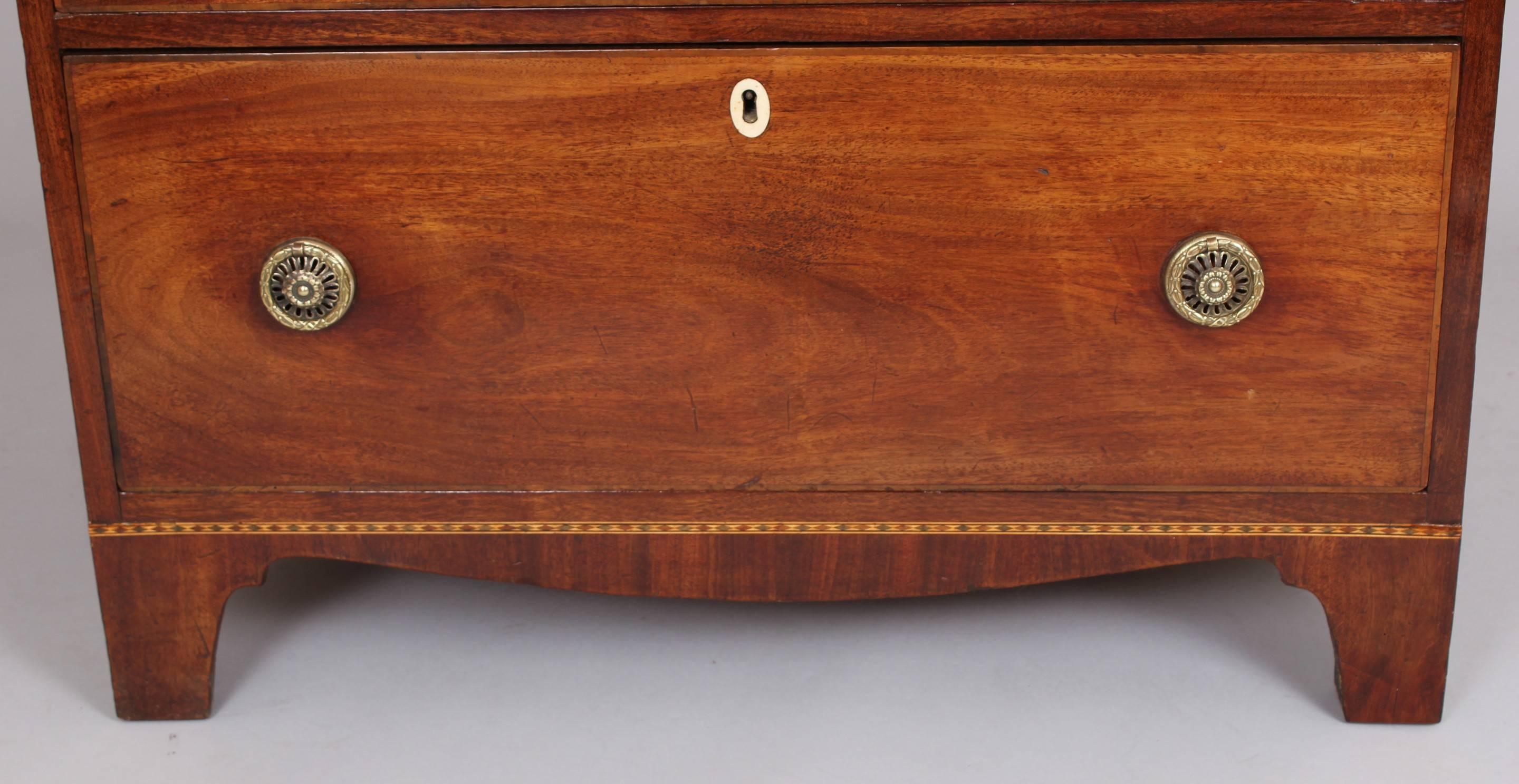 George III period mahogany chest-of-drawers of narrow proportions; the four softwood-lined drawers with inlaid ivory escutcheons and later brass ring-handles.