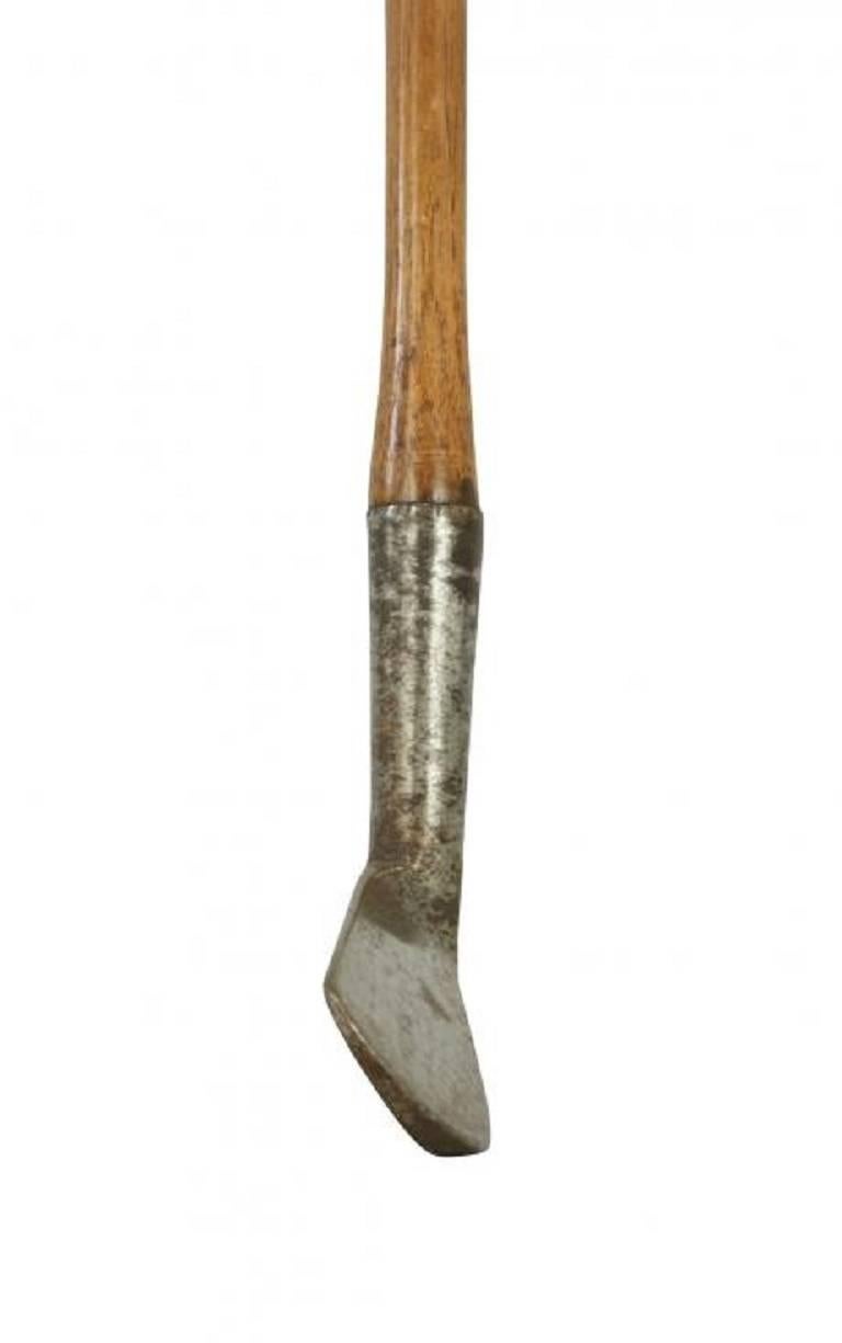 An early large head, smooth face golf club, iron. The metal club head has a nice patina with the size of the club face being 3 1/2 inches long,1 inch deep in the heel and 1 5/8 inches deep in the toe. The original hickory shaft and head stamped 'R.