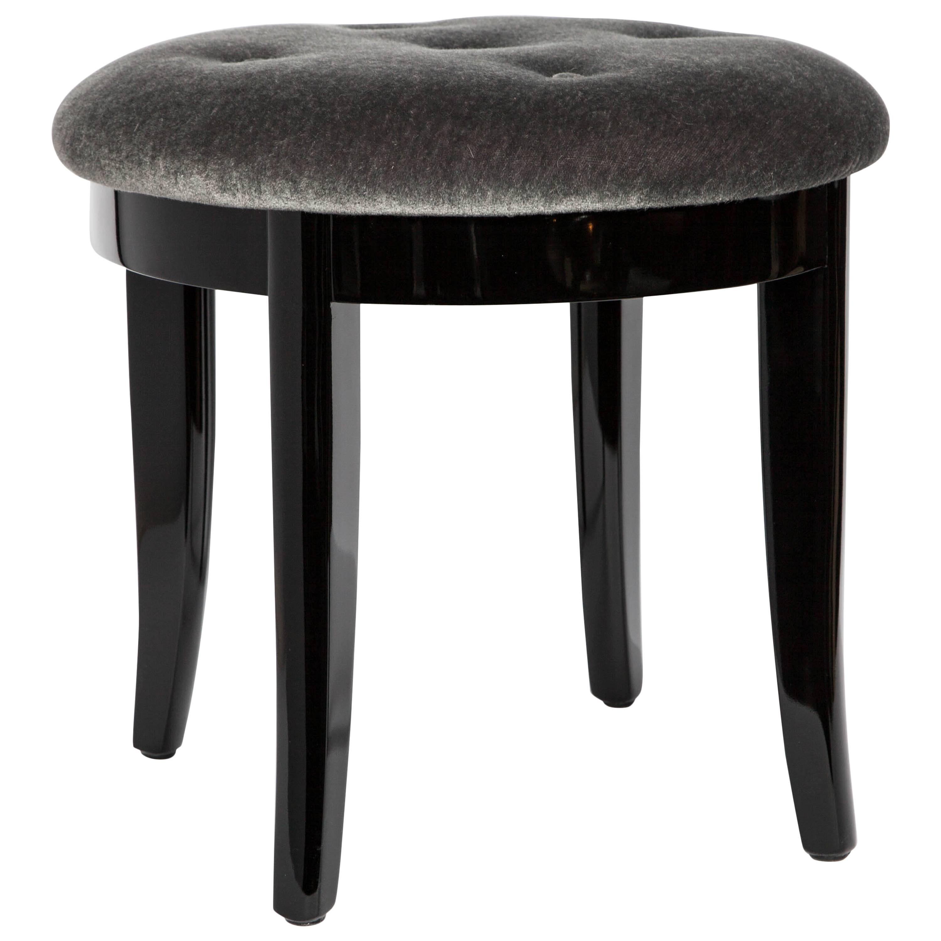 Art Deco vanity stool in a luxurious gunmetal mohair with a black lacquered finish. The stool features a round seat design with slightly splayed legs, and button seat details.