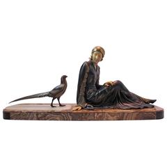 A beautiful Art Deco statue of a woman and a pheasant signed Mennoville