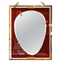 Wall mirror, Gold-plated brass and orange glass, Circa 2010, Italy.