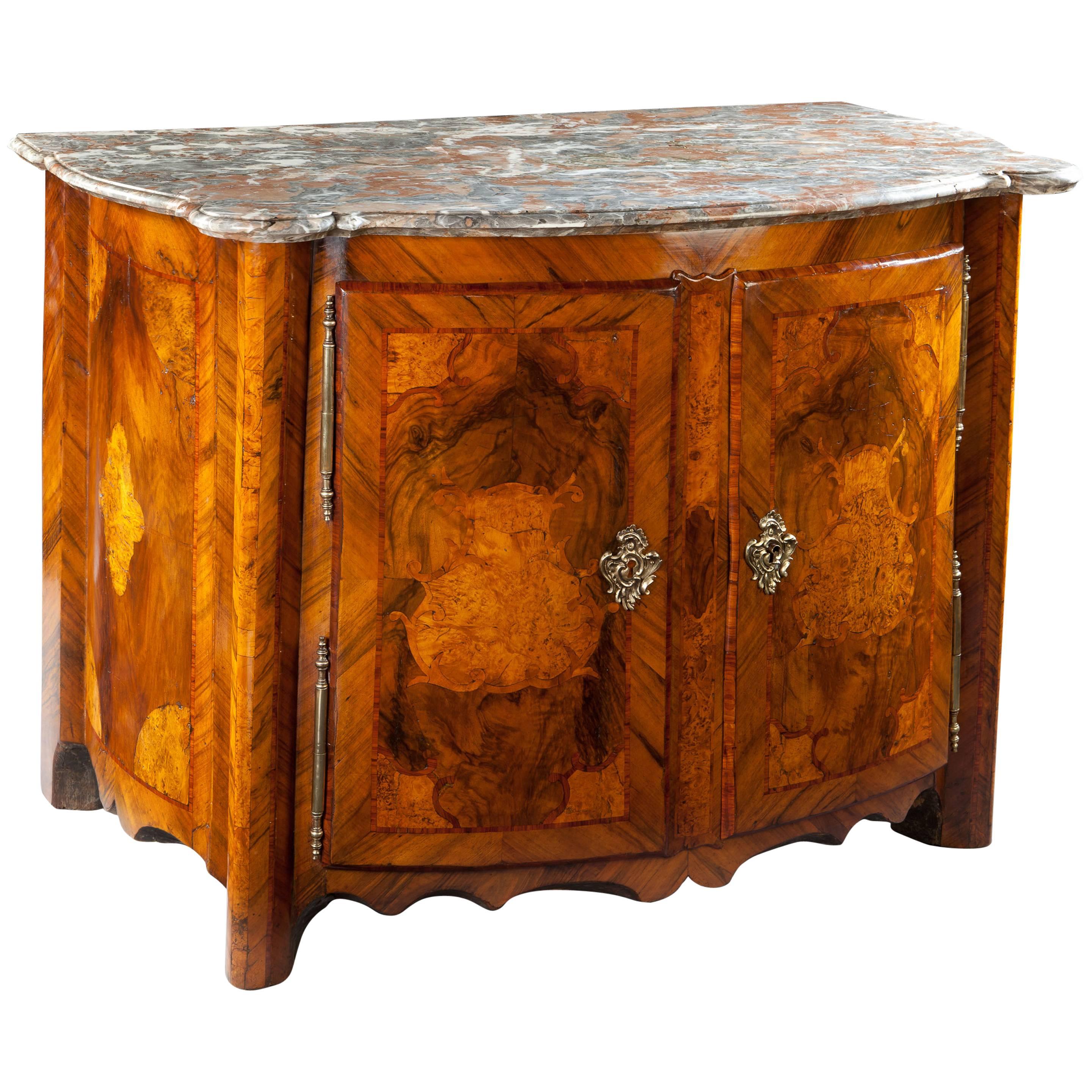 A wonderfully rich and decorative early 18th century marquetry buffet cabinet of generous proportions, veneered in highly figured timbers and retaining its original scalloped marble-top, the carcass of the cabinet is made of oak and reveals the