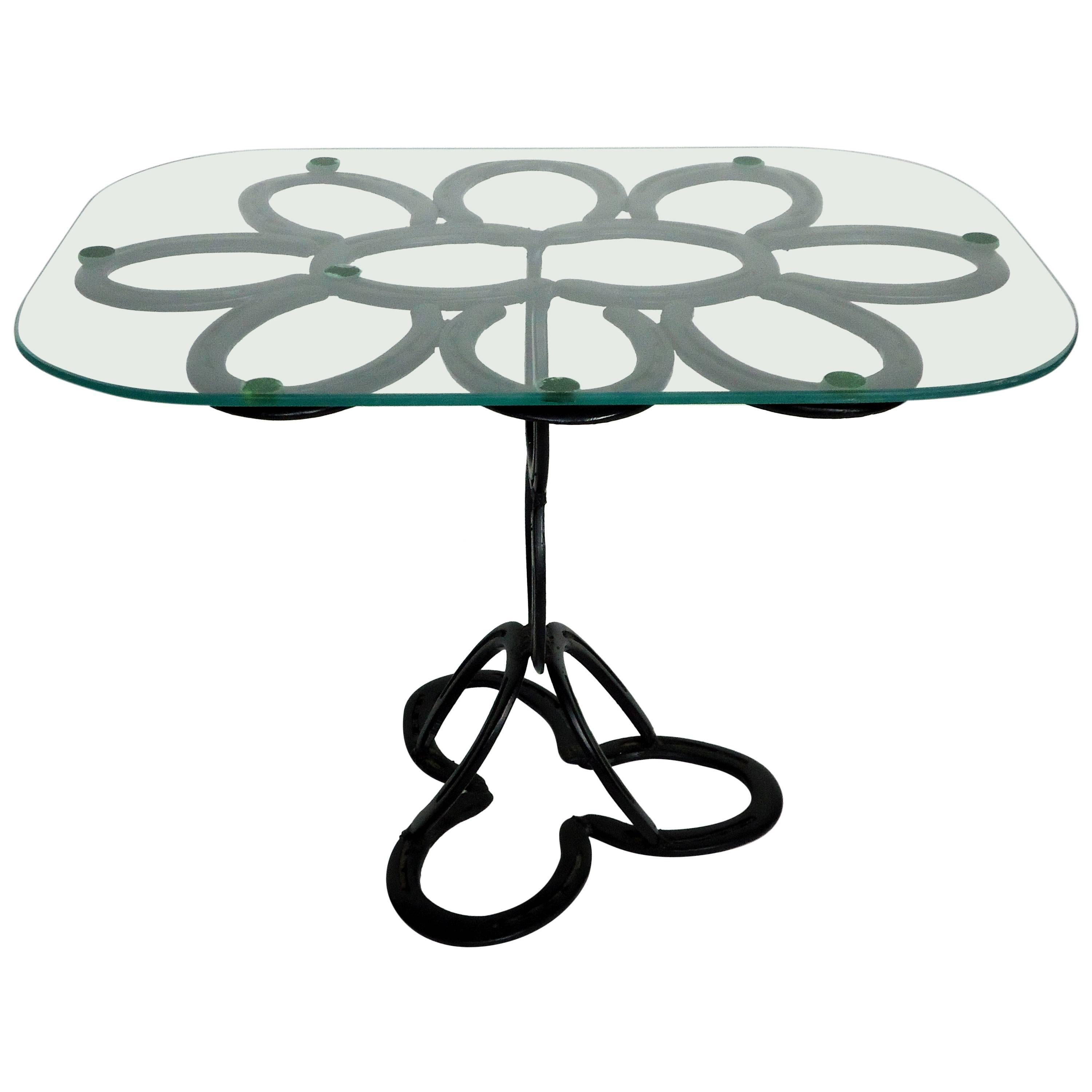 Beautiful end table composed of 17 Shetland Pony scaled iron horseshoes. The horseshoes were cast at the Saint Croix Forge in Minnesota.
The base and glass top are in excellent condition.