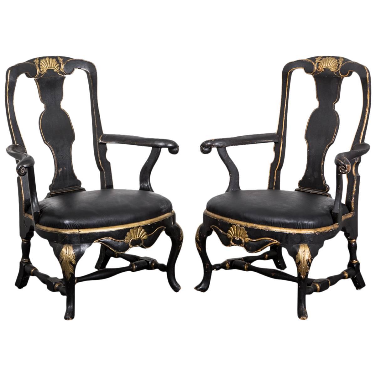 Armchairs Swedish Rococo 18th century period, Sweden. A pair of assembled Rococo armchairs. One made during the Rococo period, circa 1750 and the other made during the 1800s in Sweden. Black painted base with gilded carvings. Both chairs are