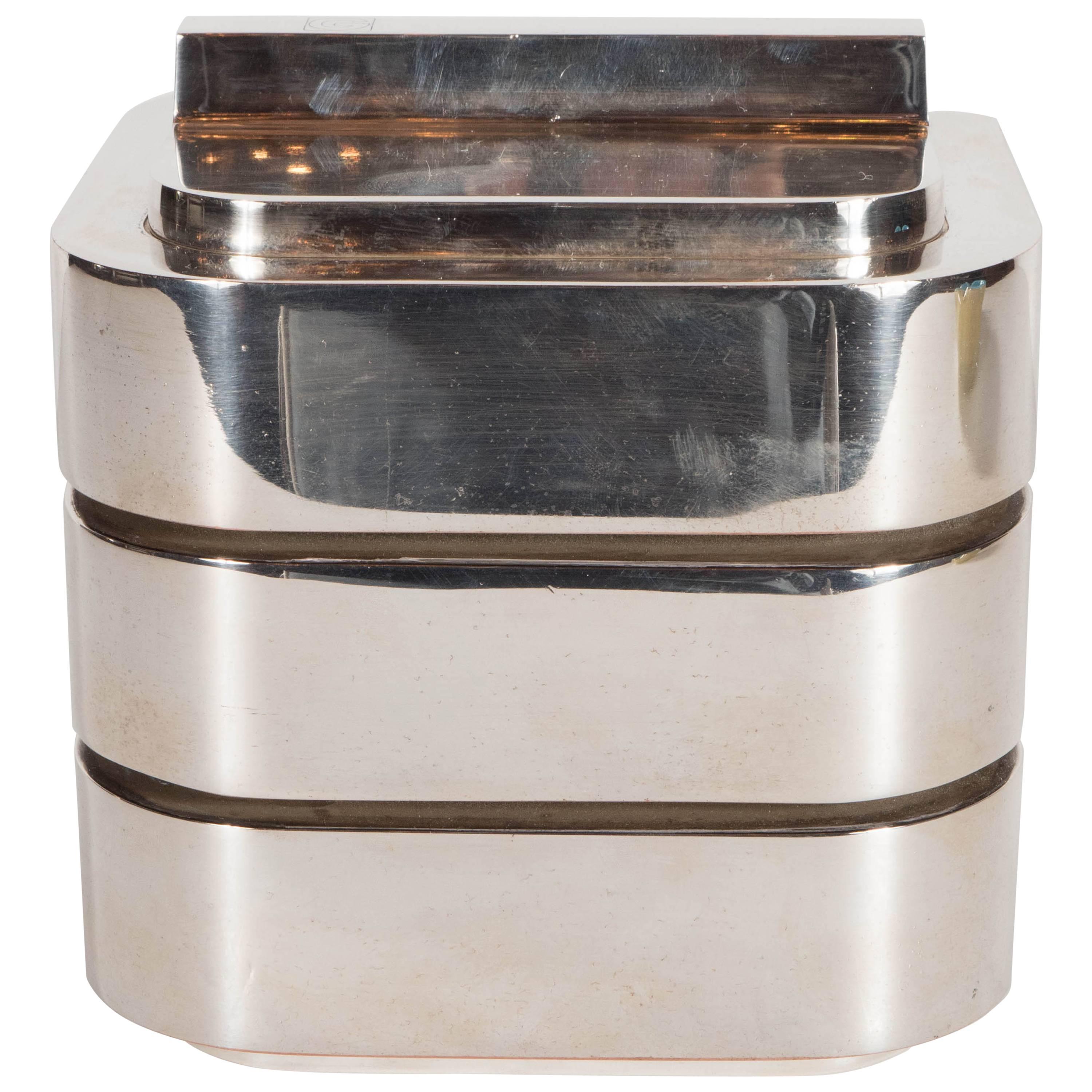 A chic Mid-Century Modernist streamlined ice bucket with lid by Christian Dior. Three levels of chrome banding make-up this perfect addition to any bar set. The inner, ivory-colored plastic lining remains intact. A secure lid fits snugly, keeping