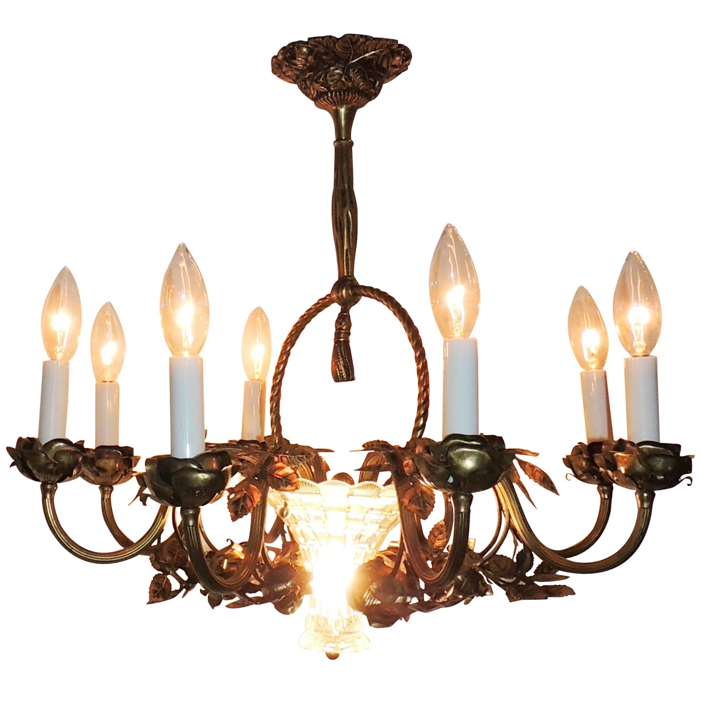 Wonderful French roses decorate bronze chandelier with both the candle cups and entwine around the eight arms. The bottom is a beautiful etched cut crystal basket which also has an interior light. 

Measures: 21