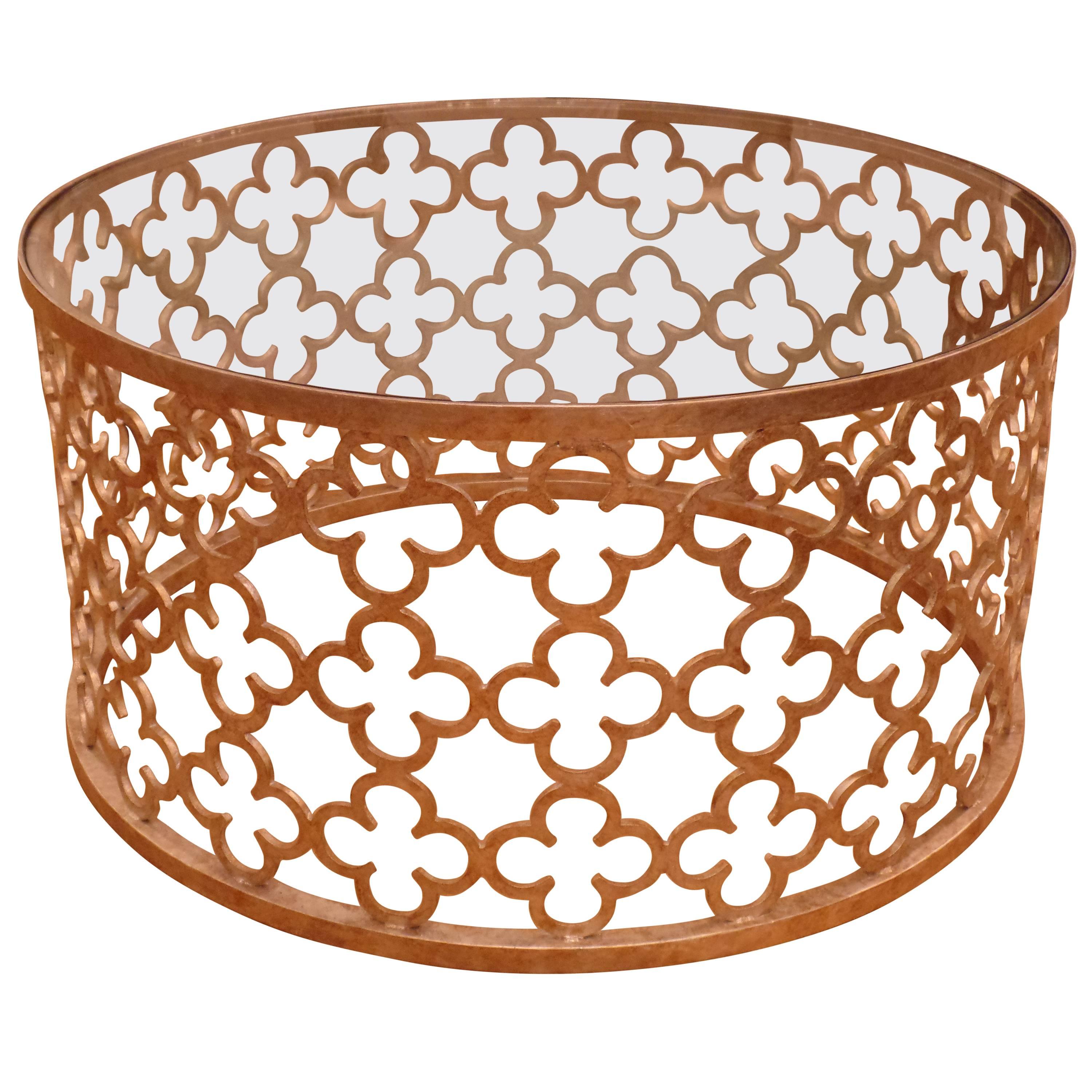 An elegant and stunning Italian Mid-Century Modern style circular wrought iron cocktail table formed of pieces of hand-wrought iron cut in quatrefoil pattern and antiqued gold on top of silver leaf. A top of clear tempered glass is set into the