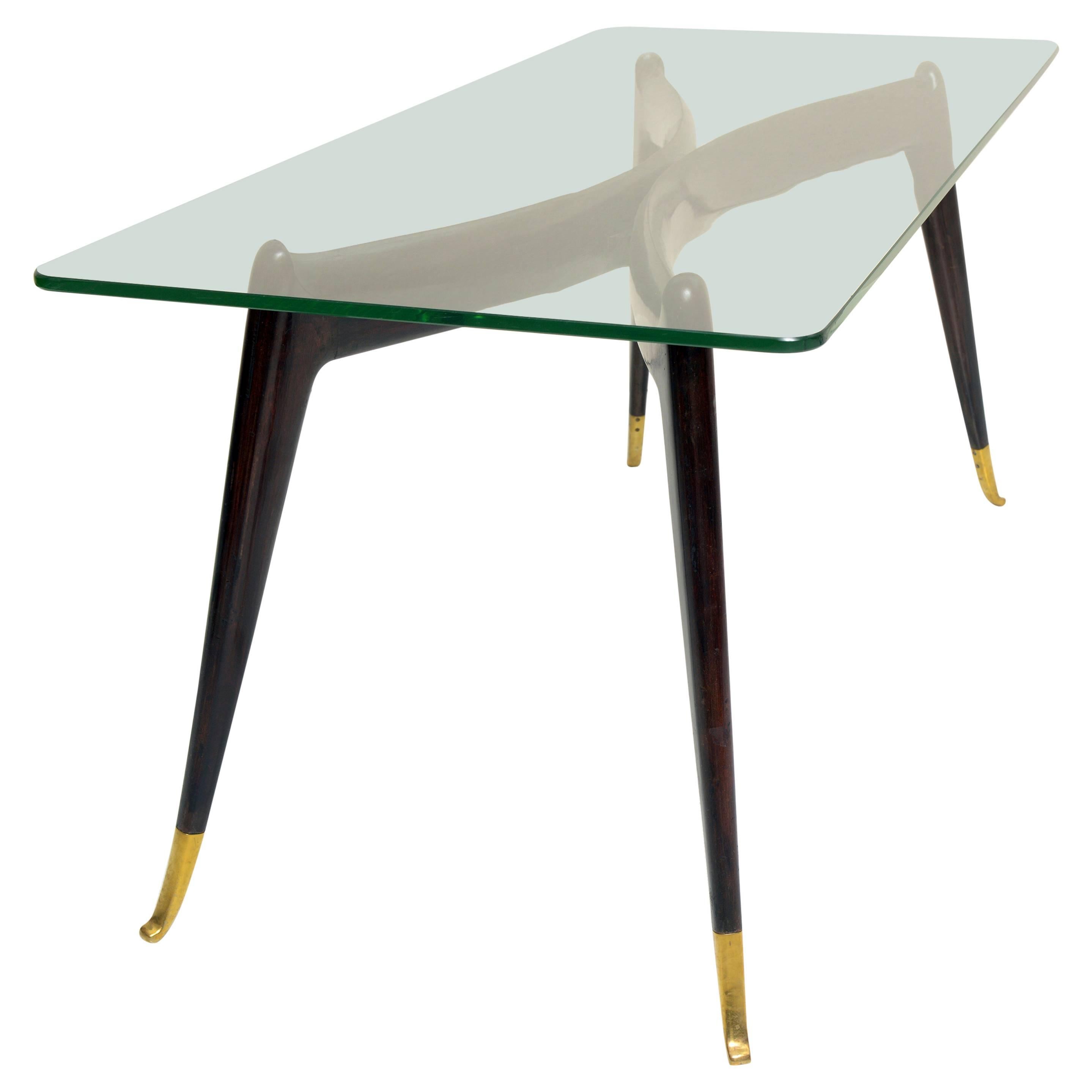 Solid sculptured wood  intersting shaped structure  and gold bronze feets details . Original  thick (8 mm) glass top.
In the style of Gio Ponti.