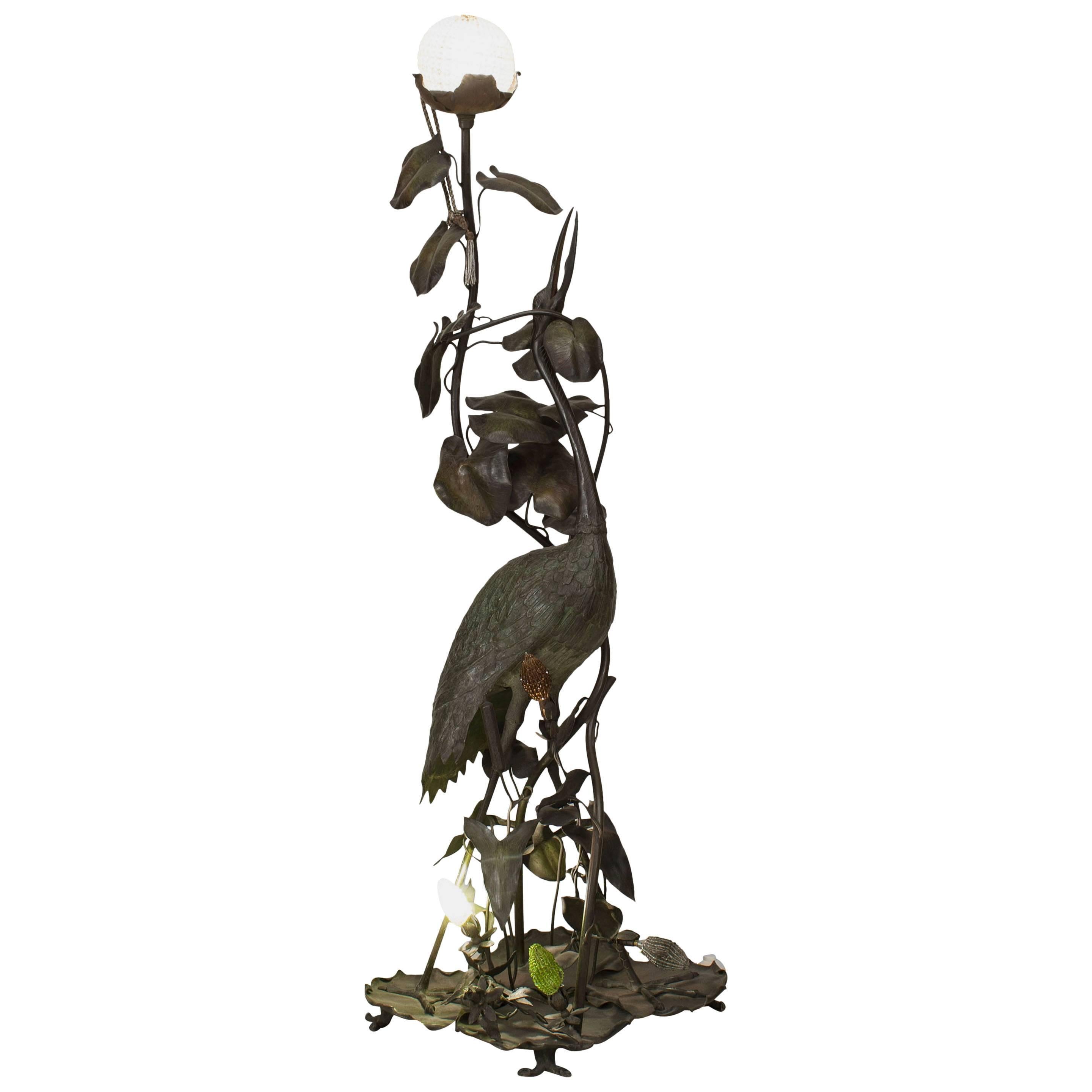 Stehlampe aus gegossenem Metall im französischen Art nouveau-Stil mit Darstellung eines Herons mit Lilienblättern