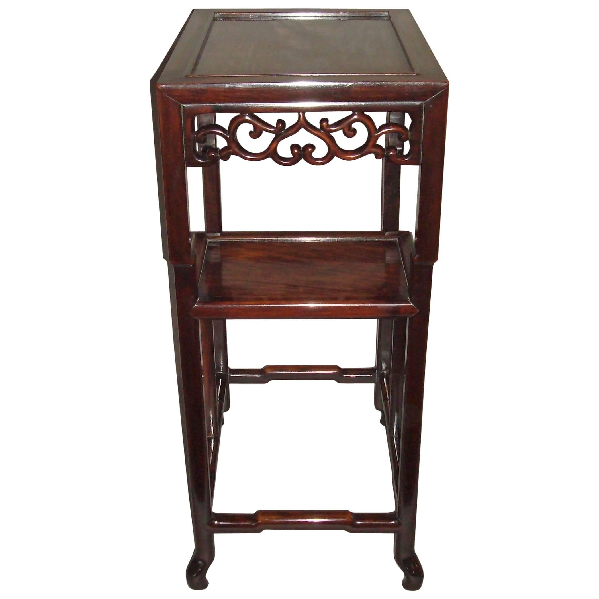 19th century Chinese Hongmu stand/table; the rectangular top with an inset figured panel above a pierced scroll work frieze with two stepped undertiers, on slightly shaped supports terminating in scrolled feet united by shaped stretchers.  Good rich