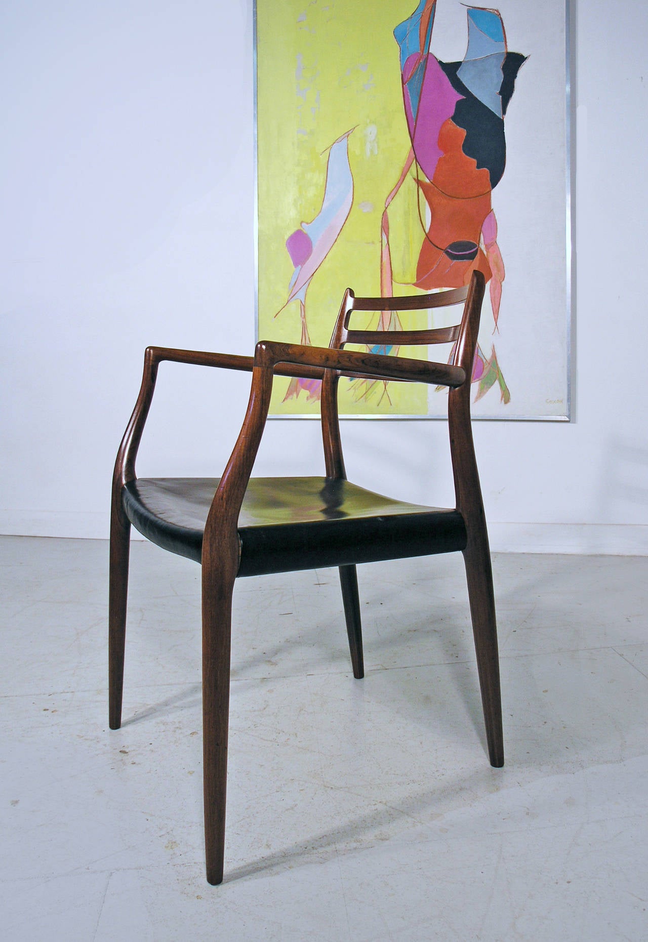 - Model 62 carver chair designed by Niels Moller 1962 for J. L. Moller, Denmark
- Excellent condition, with original black leather which shows some signs of wear.