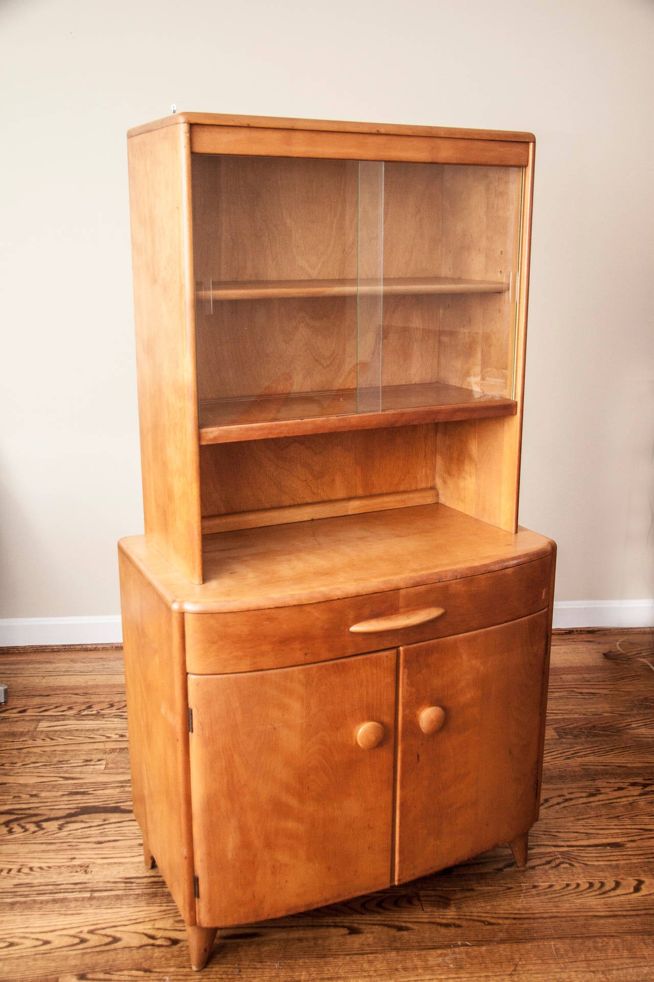 This mid century hutch by Heywood Wakefield is in great original condition.  it is a small-ish size and is not overwhelming for city living or a smaller room.  It comes in two pieces, and makes a great bar cabinet, a china cabinet, or a display